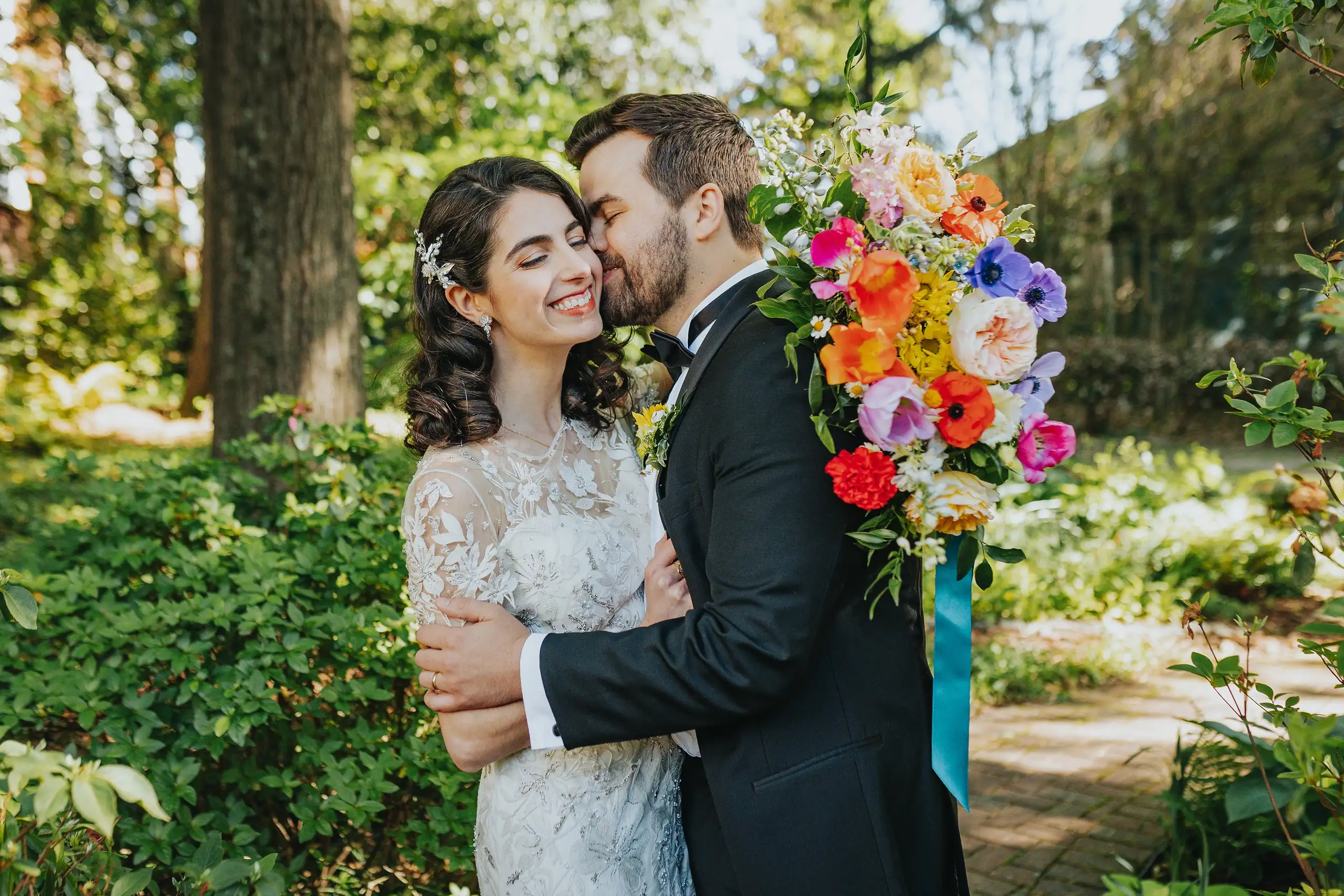 Wedding Formals: the couple embracing, her bouquet raised, at their wedding at the Trolley Barn in Atlanta, GA