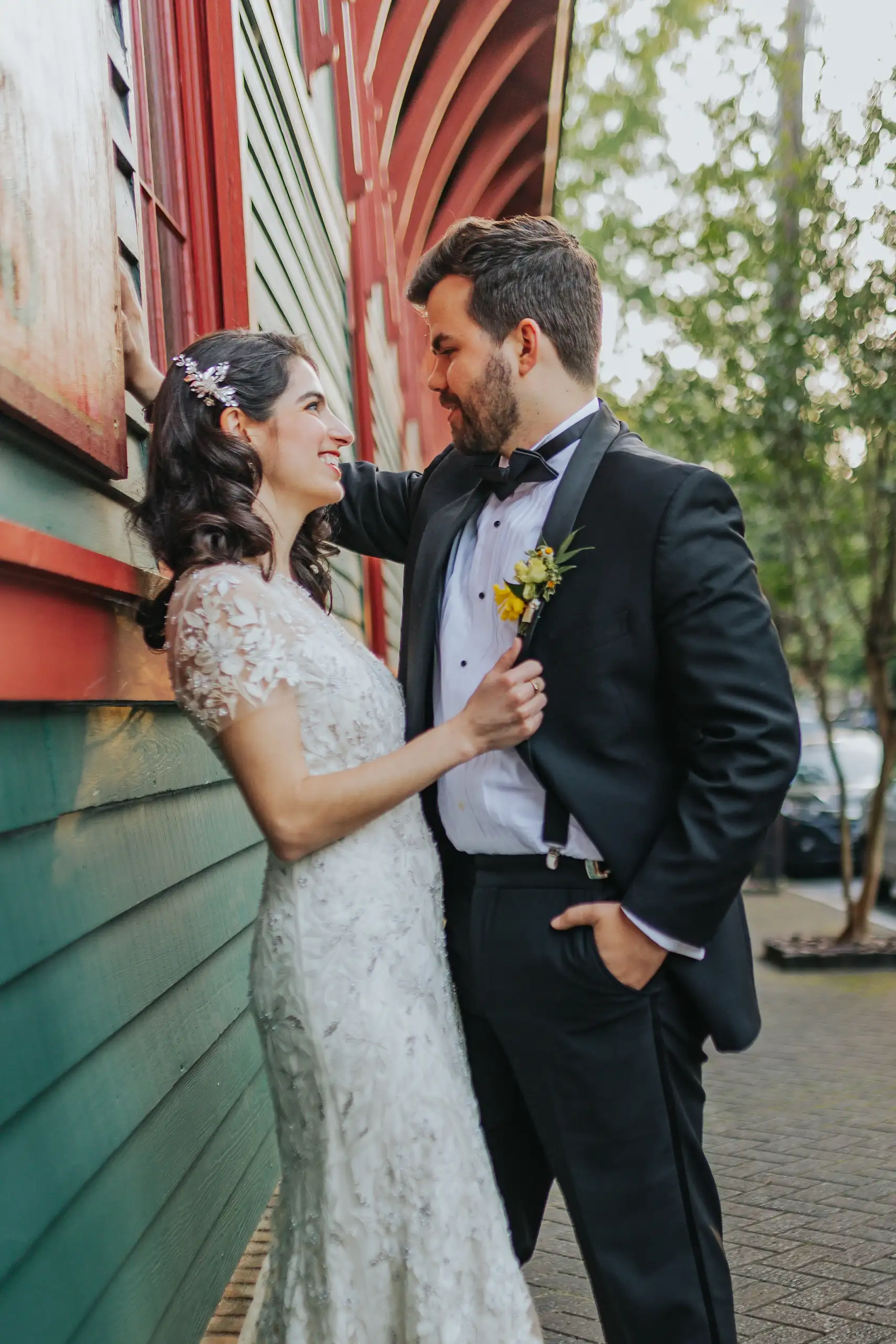Wedding Formals: the couple against the green clapboard wall, at their wedding at the Trolley Barn in Atlanta, GA