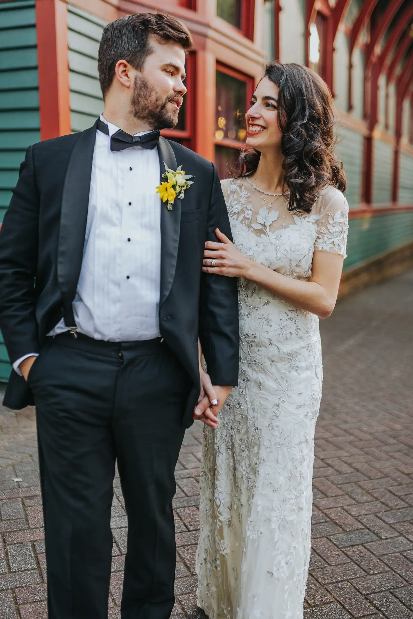 Wedding Formals: the couple walking by the green wall, laughing, at their wedding at the Trolley Barn in Atlanta, GA