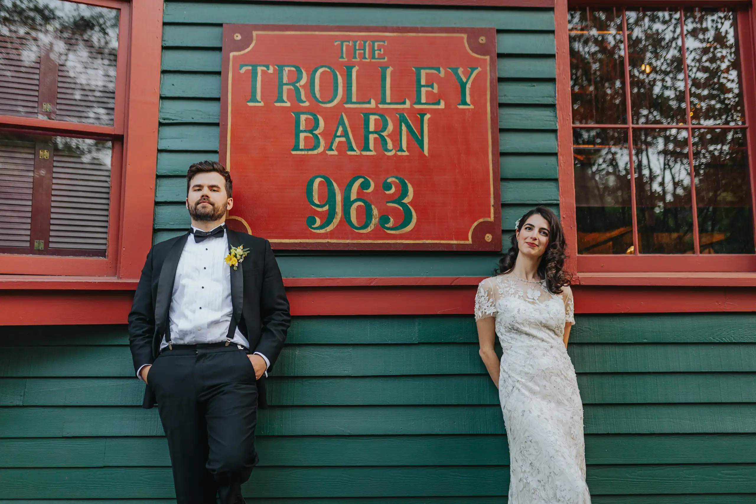 Wedding Formals: the couple beside the venue's painted sign, at their wedding at the Trolley Barn in Atlanta, GA