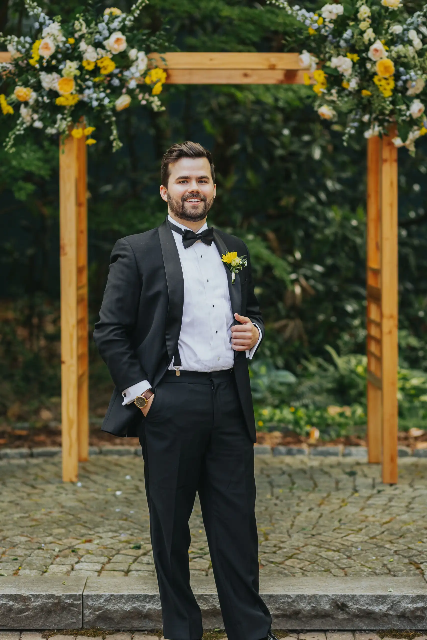 Wedding Formals: the groom beneath the flower-covered arch, at their wedding at the Trolley Barn in Atlanta, GA