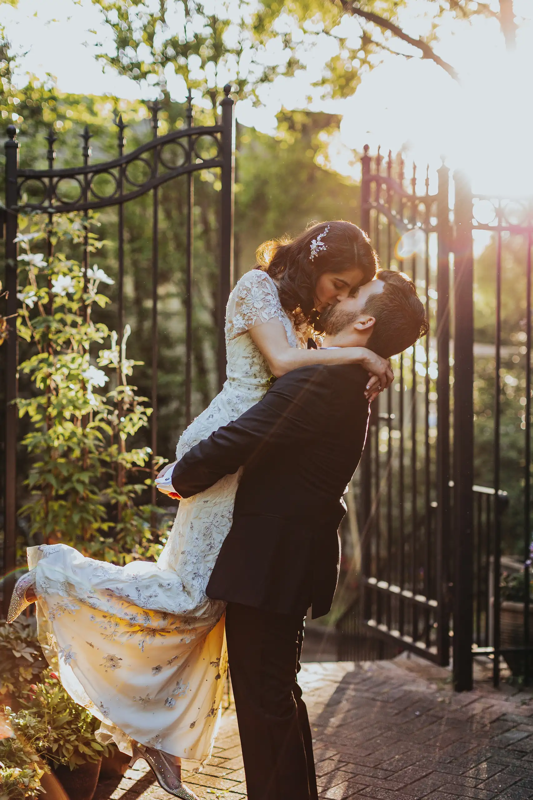 Wedding Formals: the groom lifting the bride at the gate, at their wedding at the Trolley Barn in Atlanta, GA