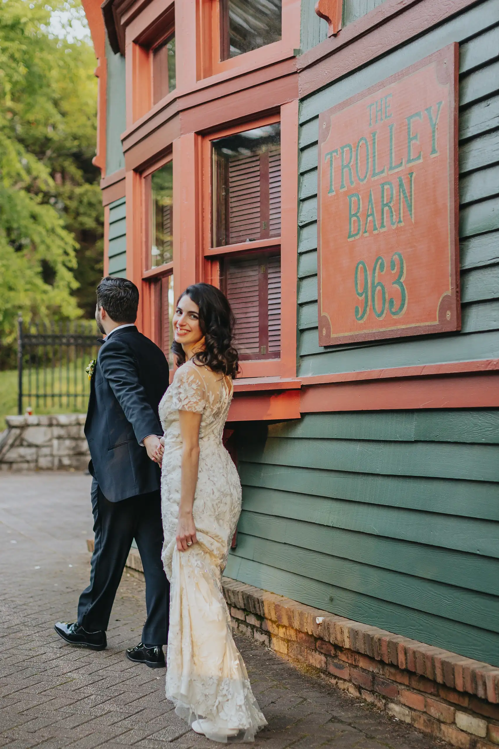 Wedding Formals: the couple by the venue sign on the brick, at their wedding at the Trolley Barn in Atlanta, GA