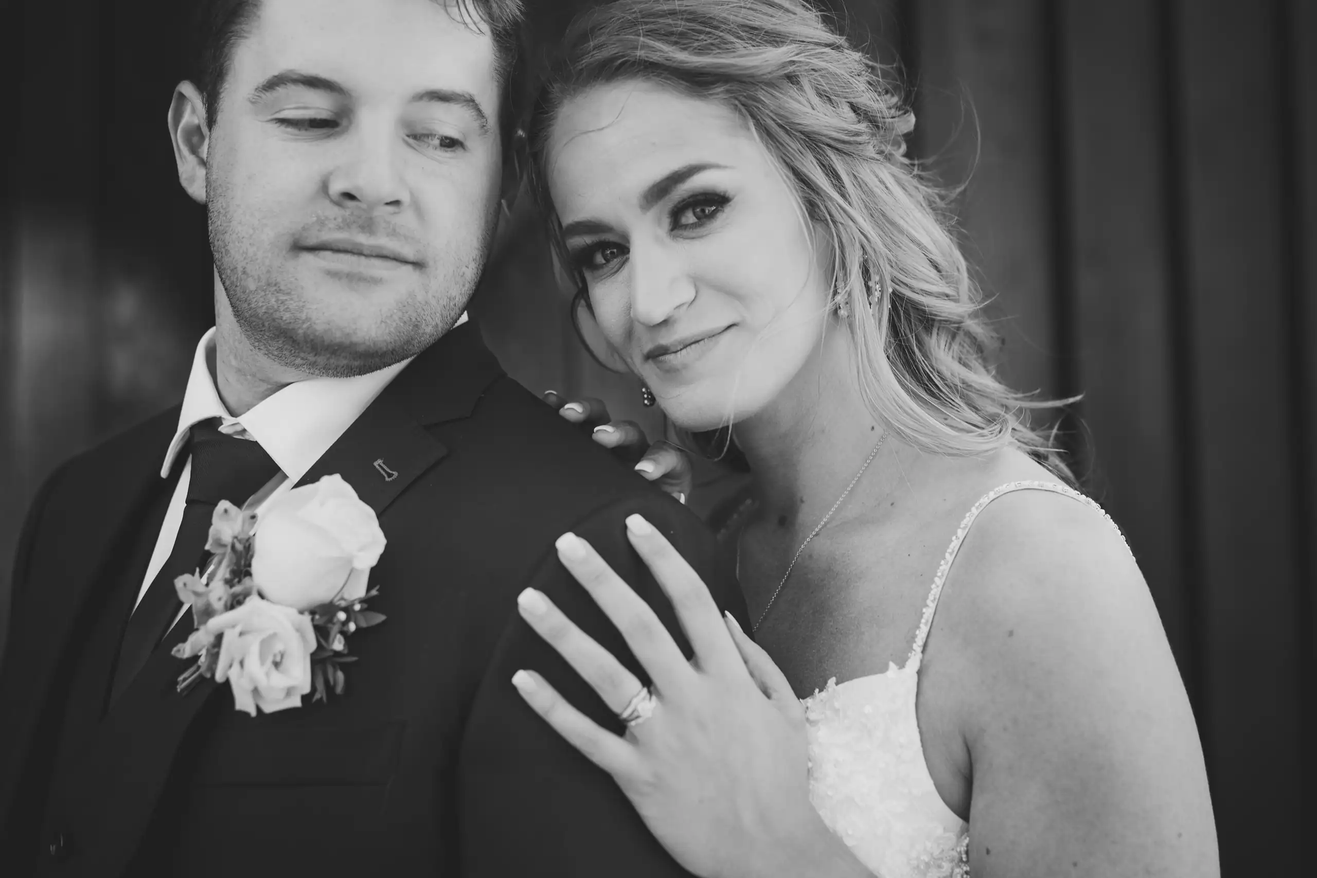 Wedding Details: her ring hand on his lapel, in black and white, at a wedding at The Venue at Sharp Mountain in Jasper, GA