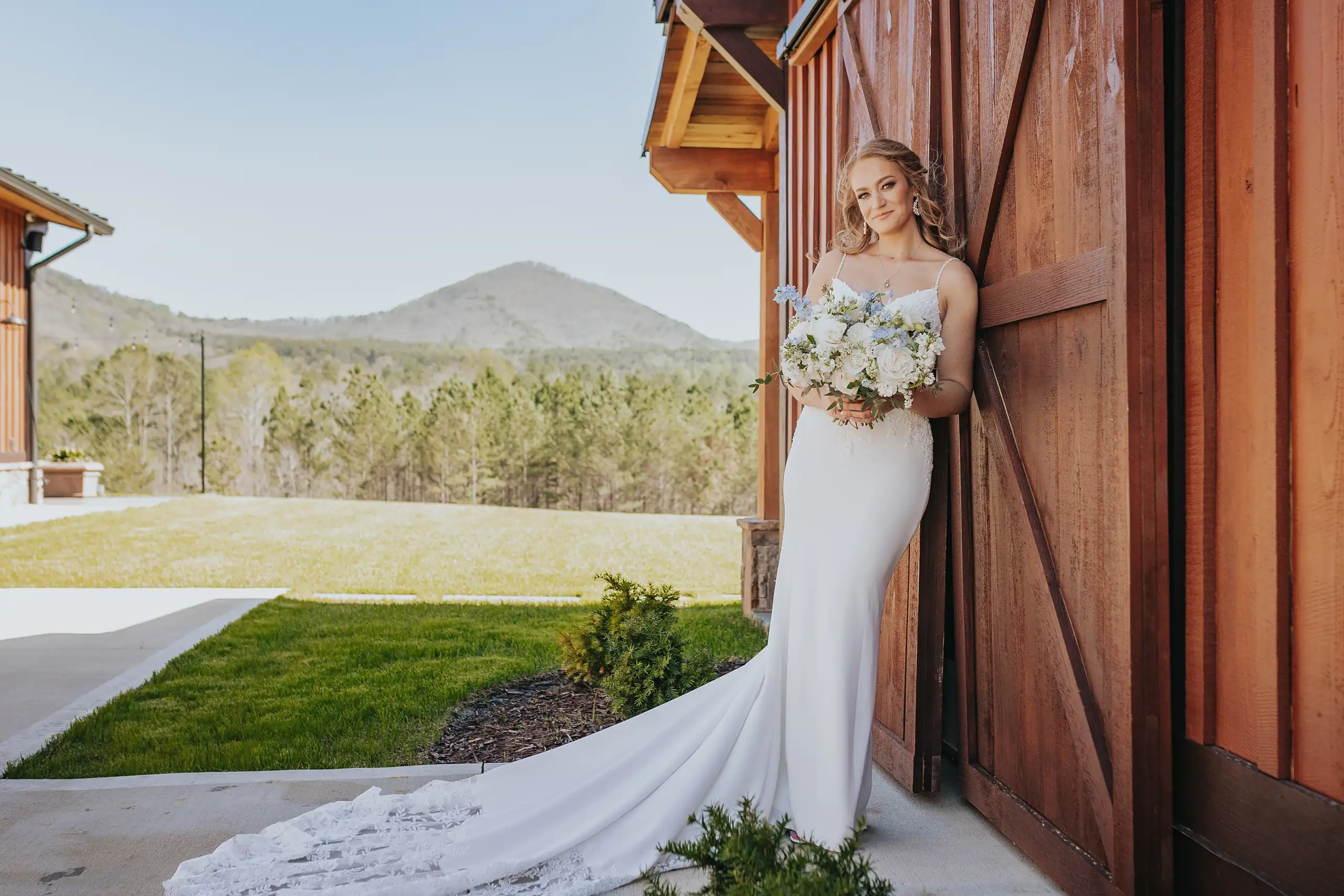 Bridal Portraits: the bride and her train at the barn doors, at their wedding at The Venue at Sharp Mountain in Jasper, GA