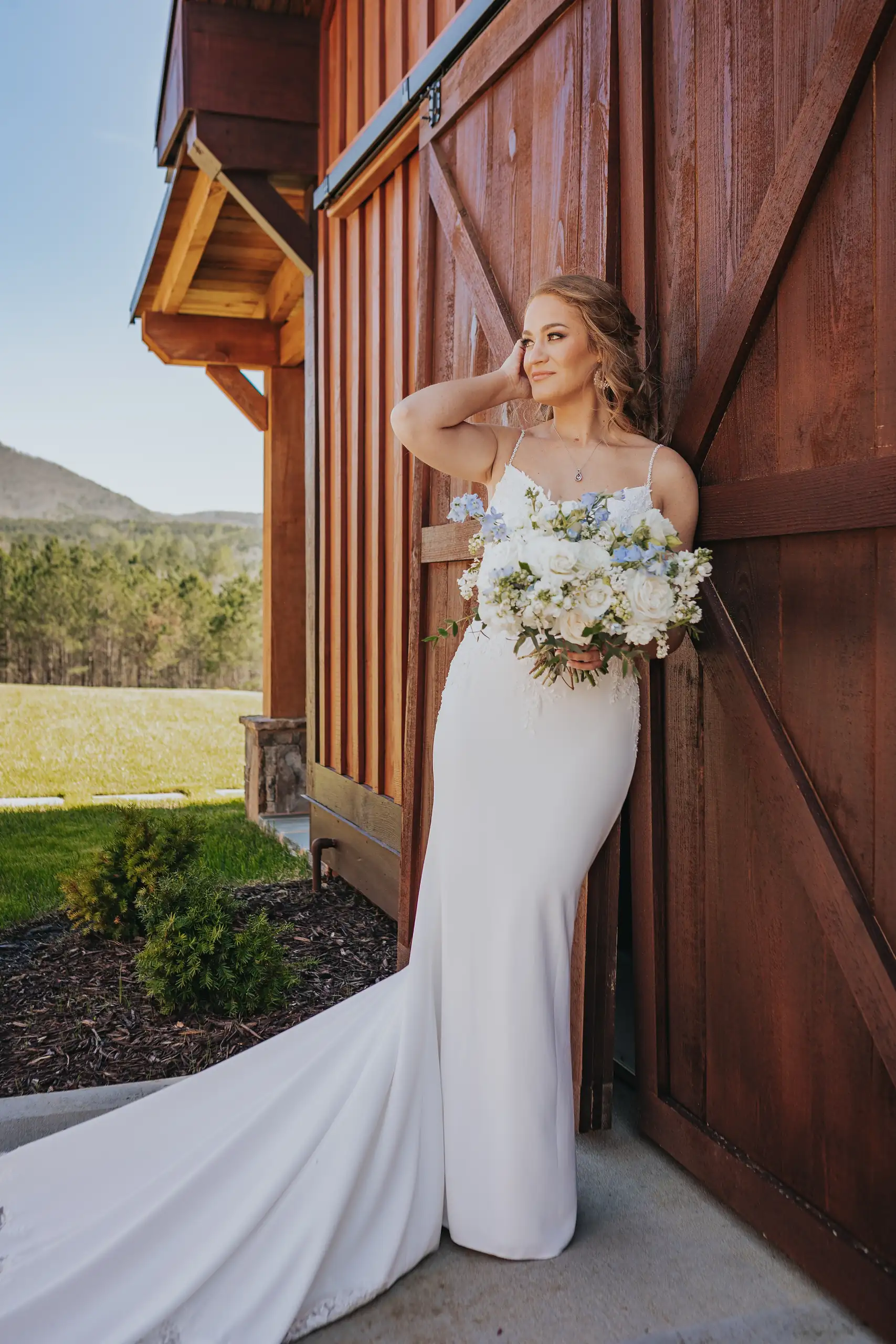 Bridal Portraits: the bride against the barn, the view beyond, at their wedding at The Venue at Sharp Mountain in Jasper, GA