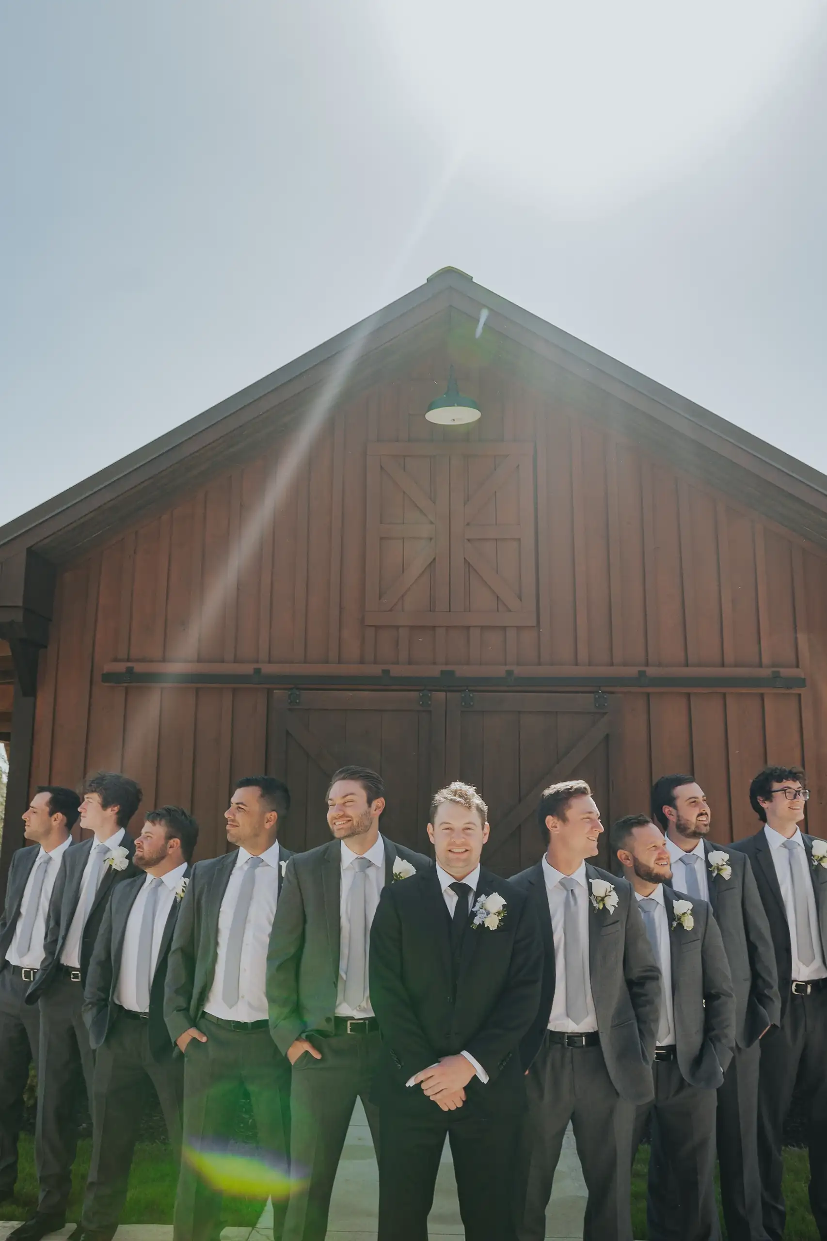 Wedding Party: the groomsmen with the sun behind the gable, at their wedding at The Venue at Sharp Mountain in Jasper, GA