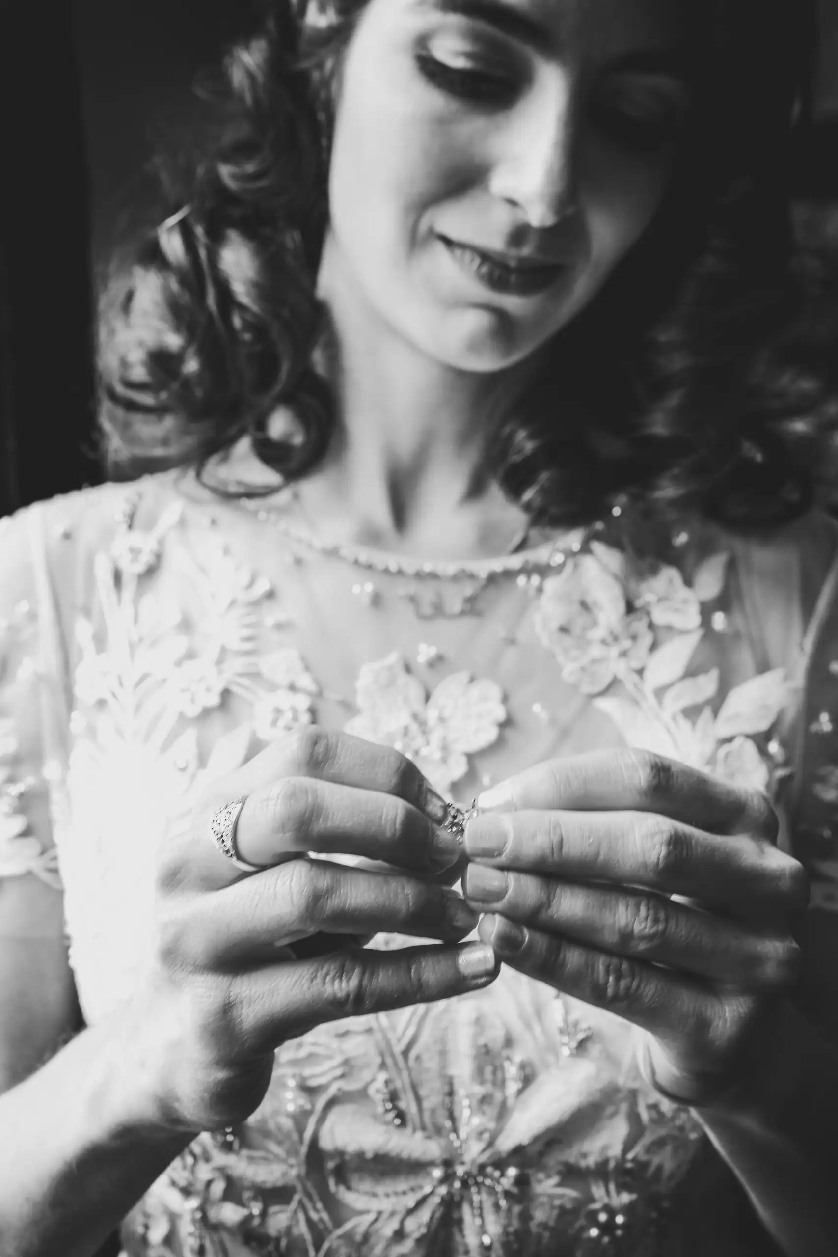 Getting Ready: the bride looking down at her rings, in black and white, before their wedding at the Trolley Barn in Atlanta, GA