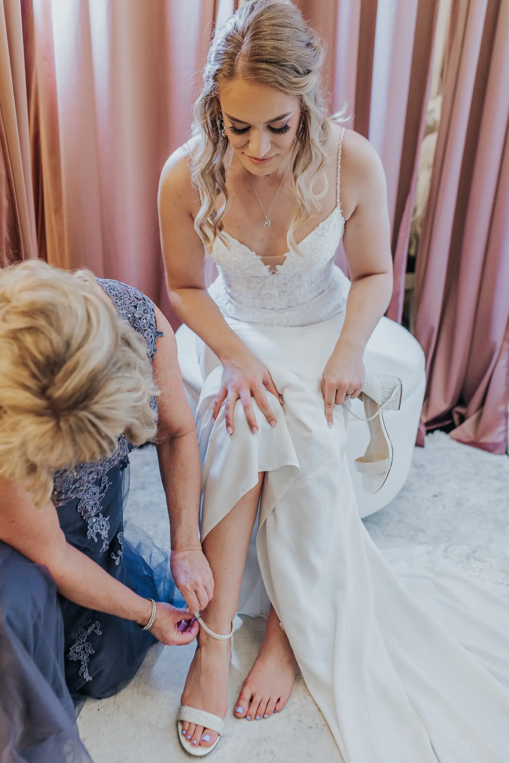 Getting Ready: her mother fastening her shoe, before their wedding at The Venue at Sharp Mountain in Jasper, GA