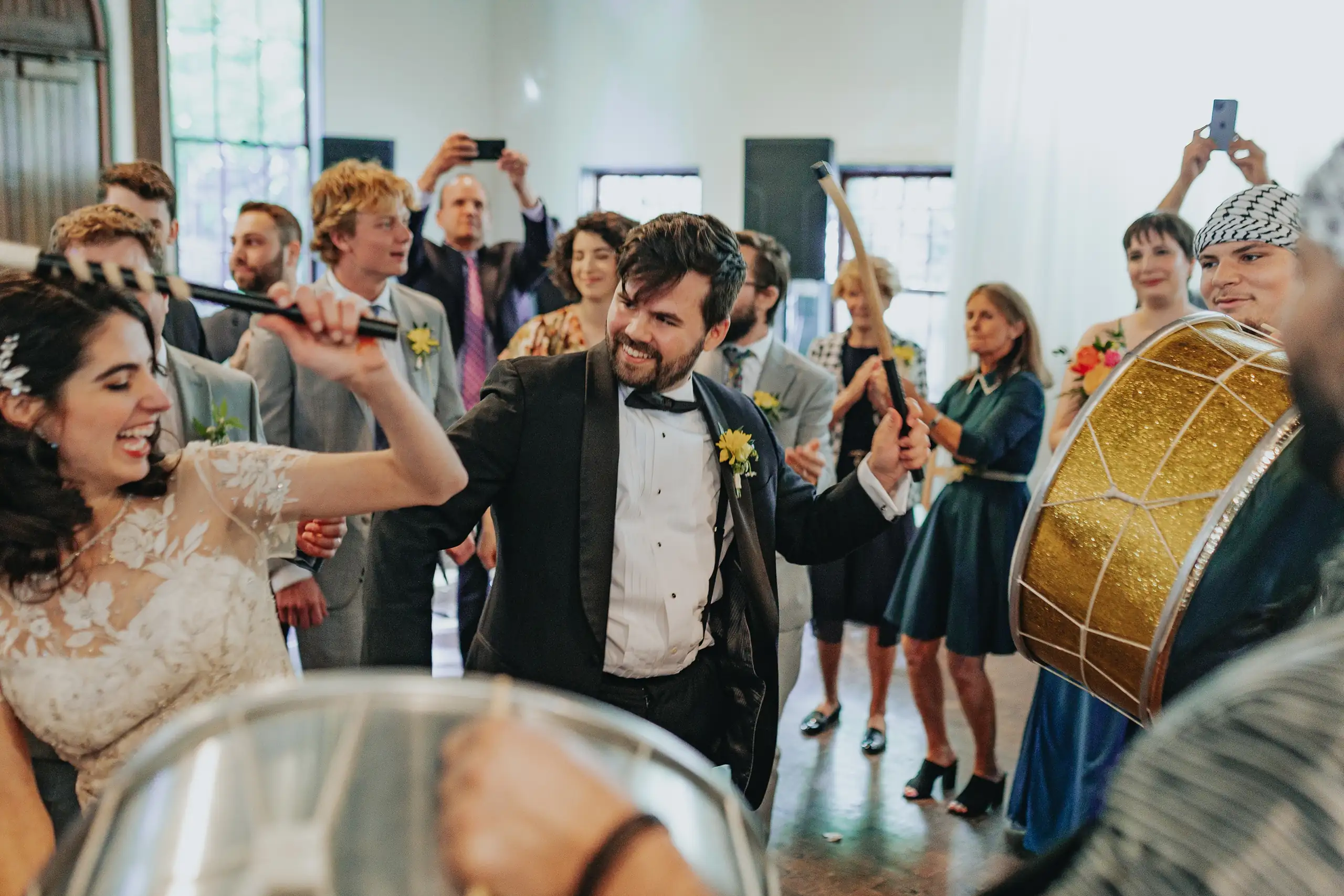 Wedding Reception: the couple leading the dance, a drum behind them, at their wedding at the Trolley Barn in Atlanta, GA