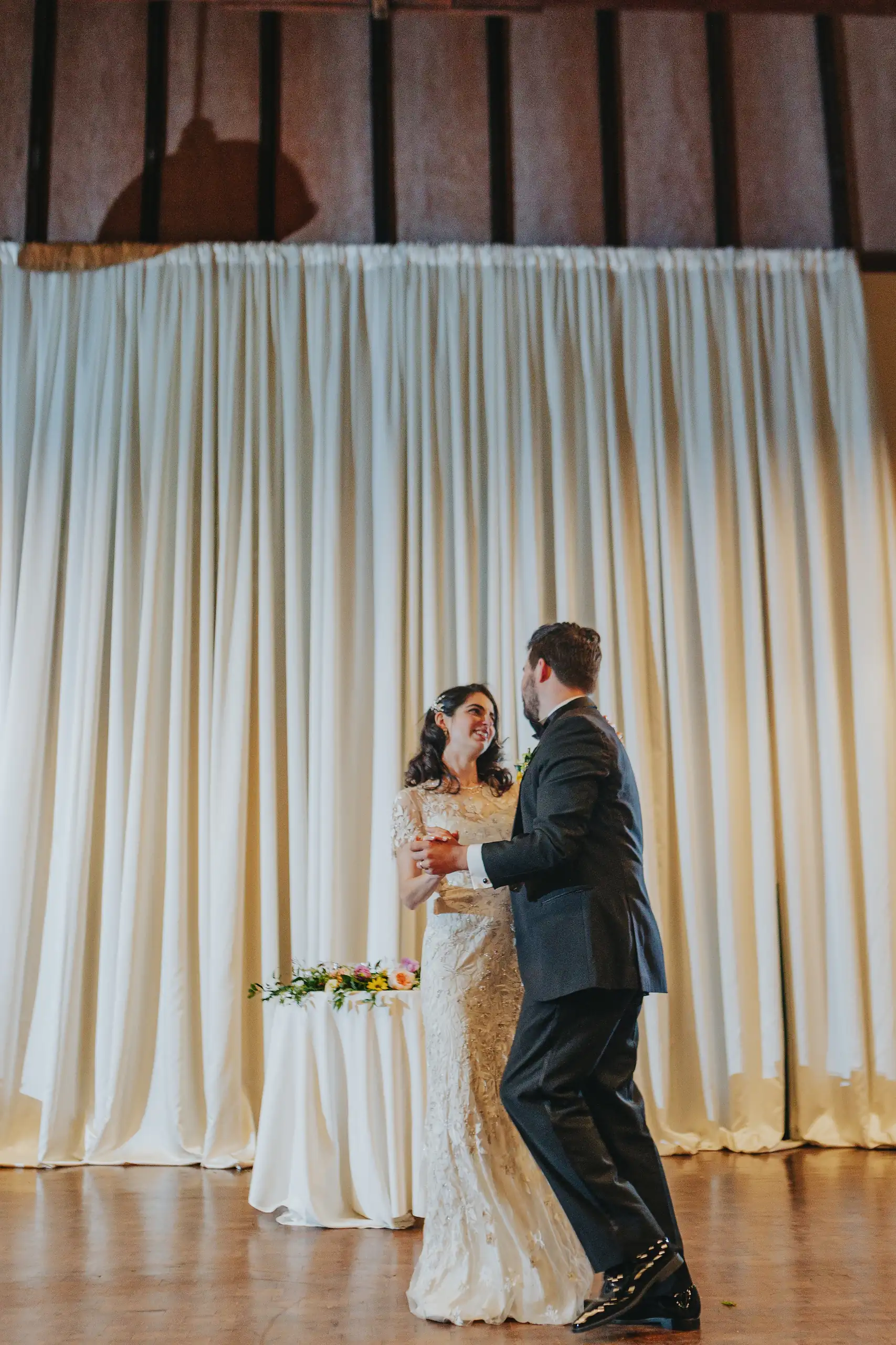 First Dance: the couple dancing before the draped wall, at their wedding at the Trolley Barn in Atlanta, GA