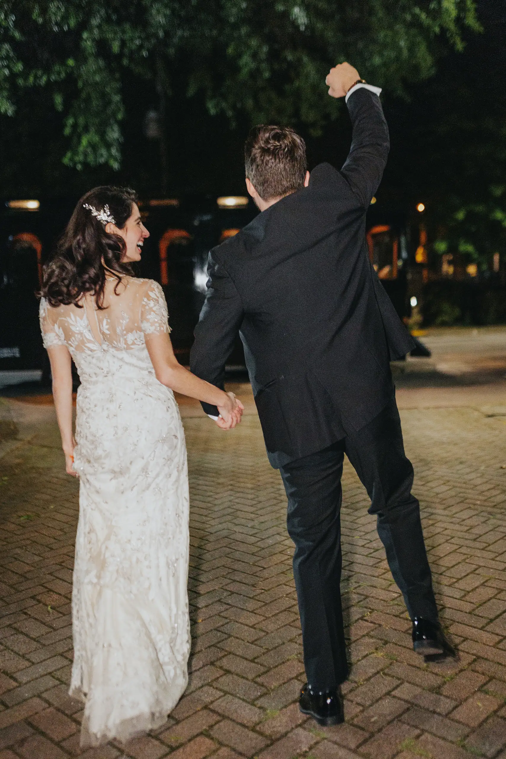 Send-Off: the couple walking away, the groom's fist raised, at their wedding at the Trolley Barn in Atlanta, GA