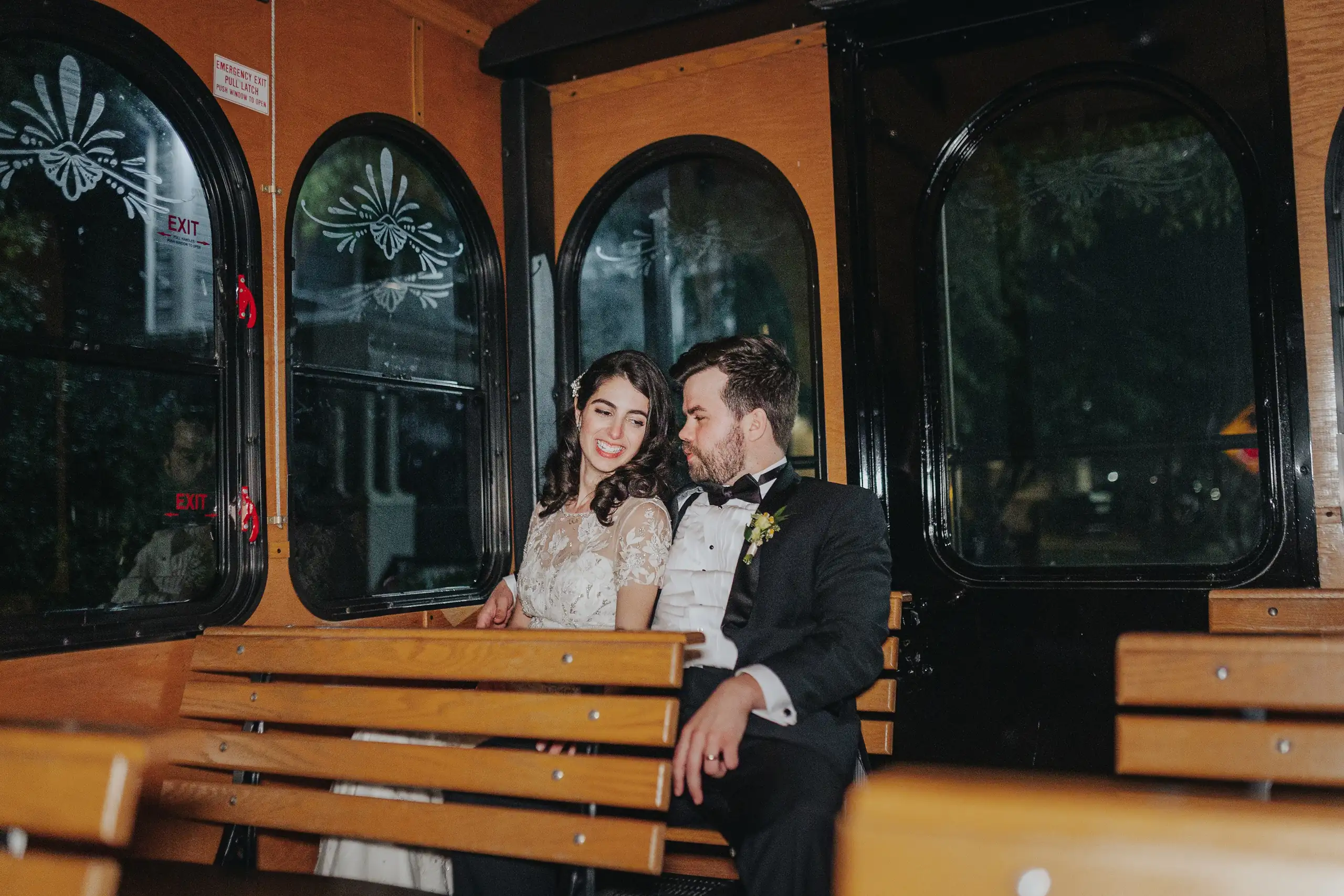 Send-Off: the couple seated on the trolley car bench, at their wedding at the Trolley Barn in Atlanta, GA