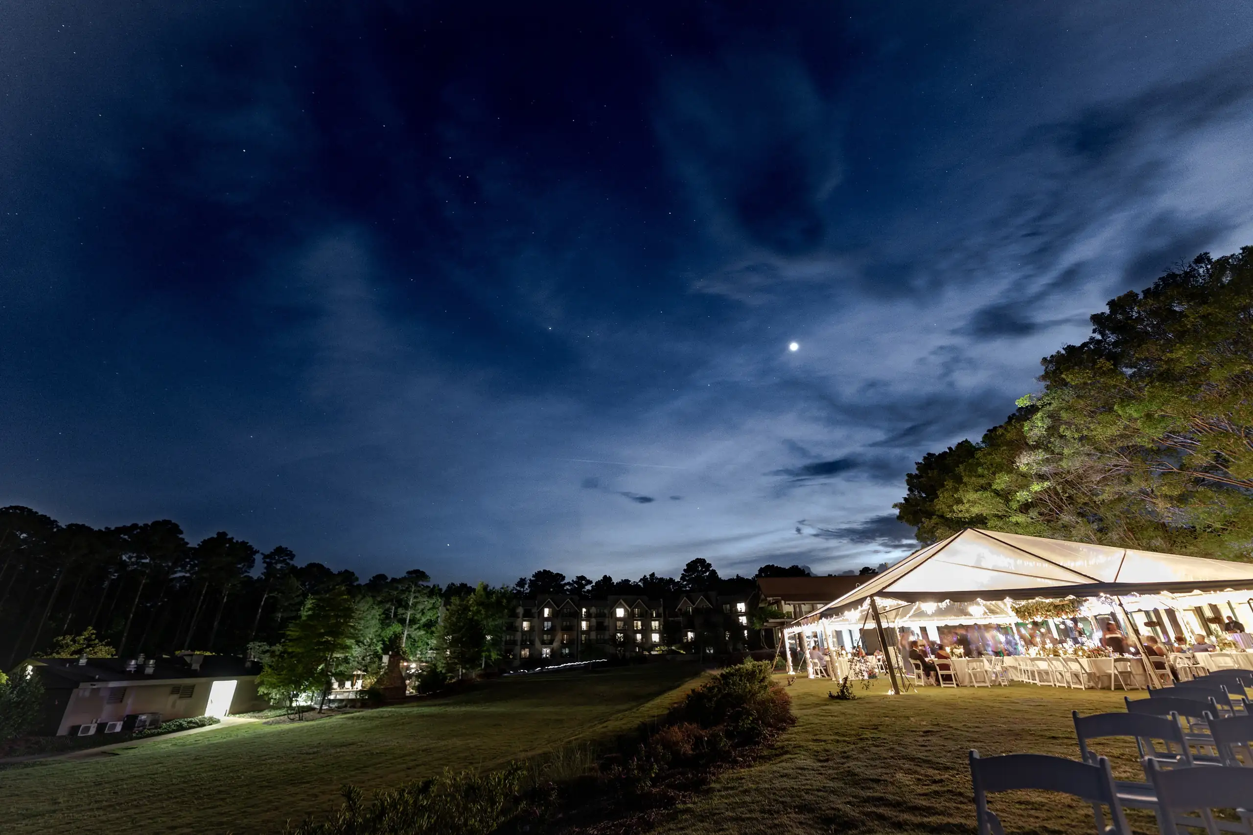 Wedding Reception: the tent lit up under a blue night sky and the moon, at a wedding at Callaway Gardens in Pine Mountain, GA
