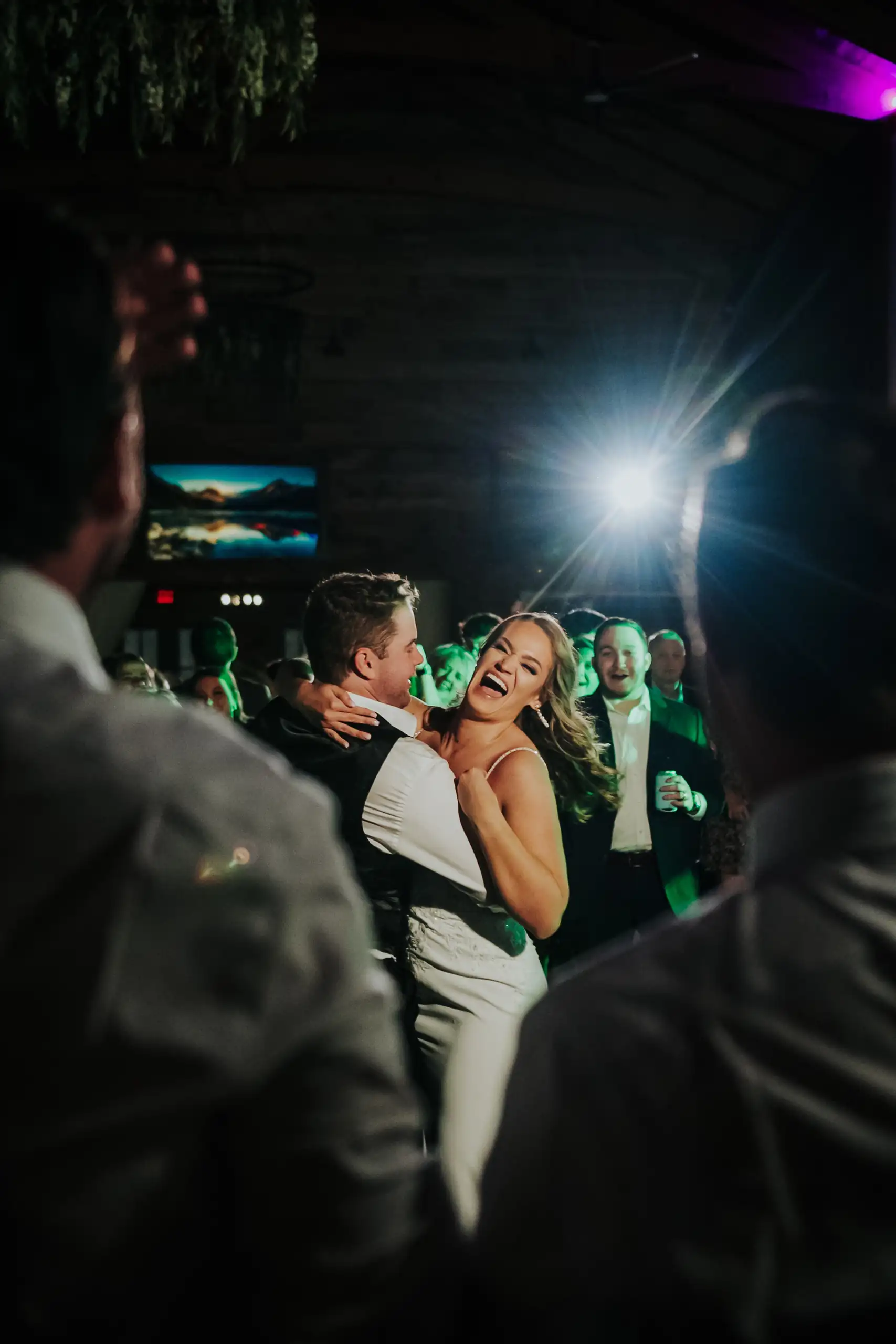 Wedding Reception: the couple dancing in the crowd after dark, at their wedding at The Venue at Sharp Mountain in Jasper, GA