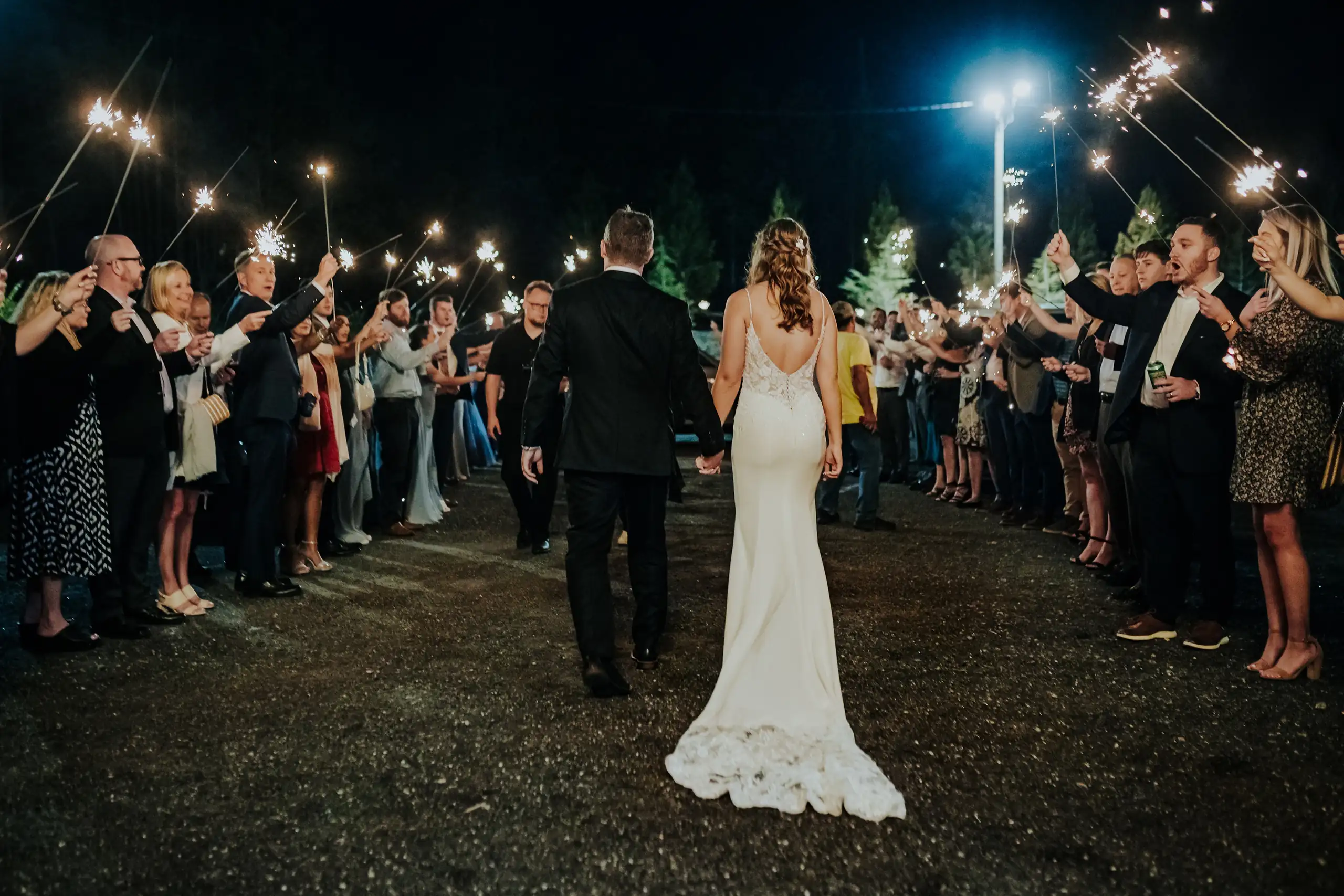Sparkler Exit: the couple walking out through the sparklers, at their wedding at The Venue at Sharp Mountain in Jasper, GA