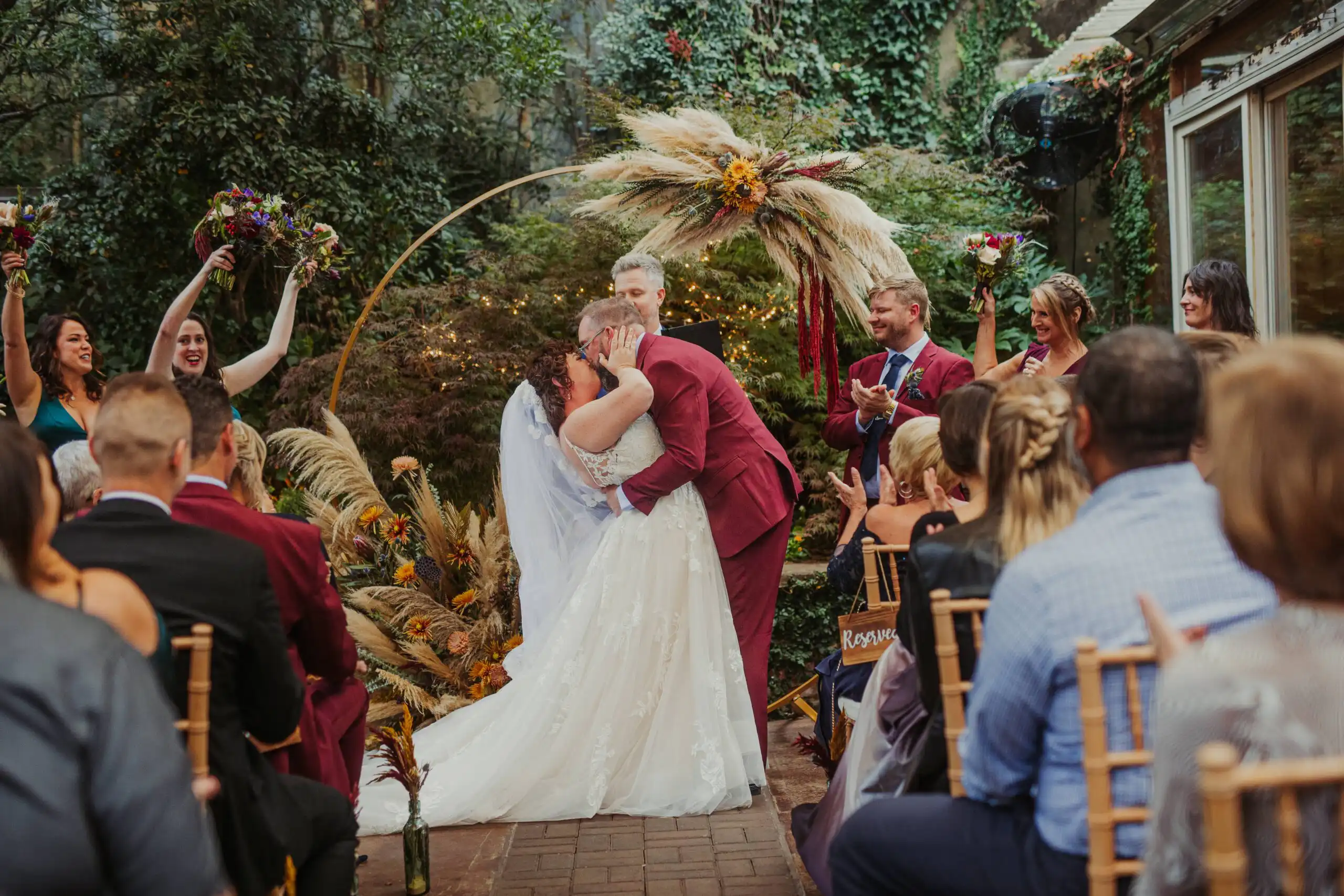 Wedding Ceremony: a kiss at the pampas ring as the guests cheer, at their wedding at Wahoo! Grill in Decatur, GA