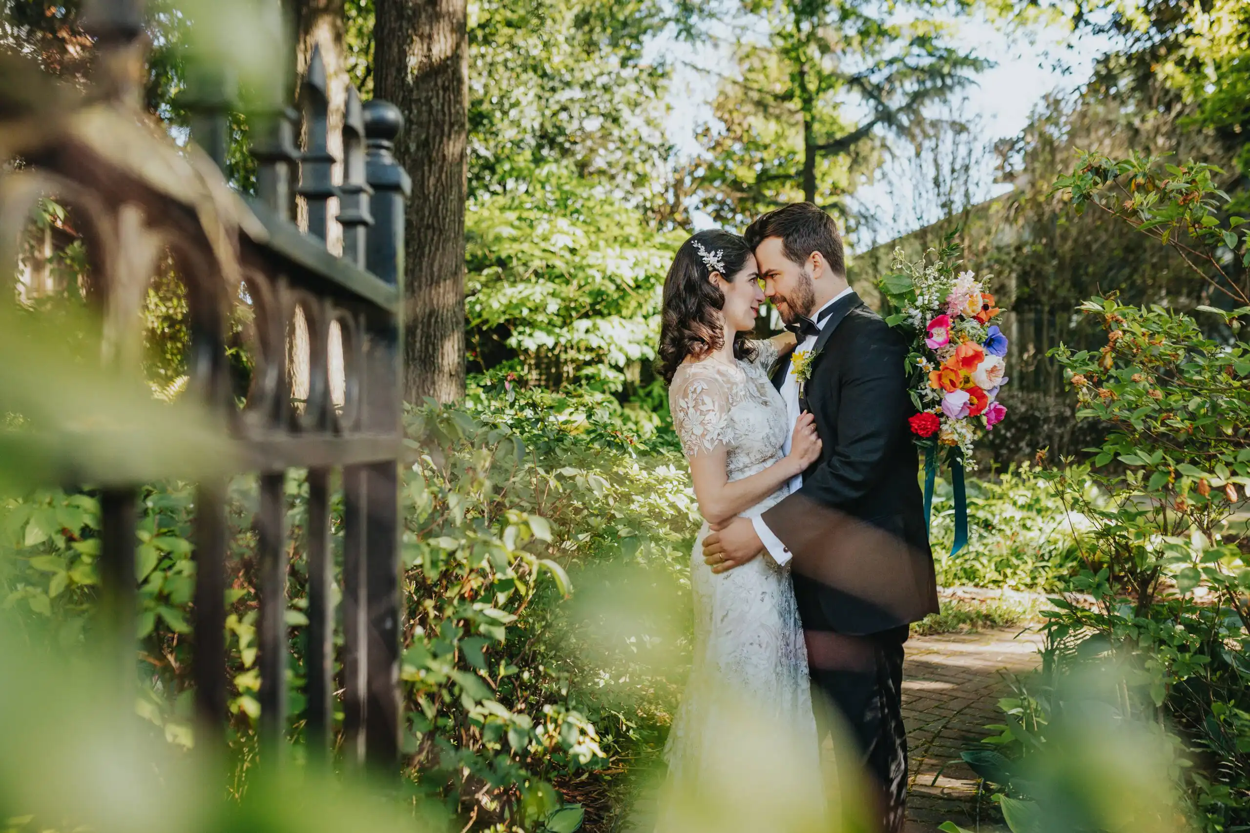 Wedding Formals: the couple framed through leaves and ironwork, at their wedding at the Trolley Barn in Atlanta, GA