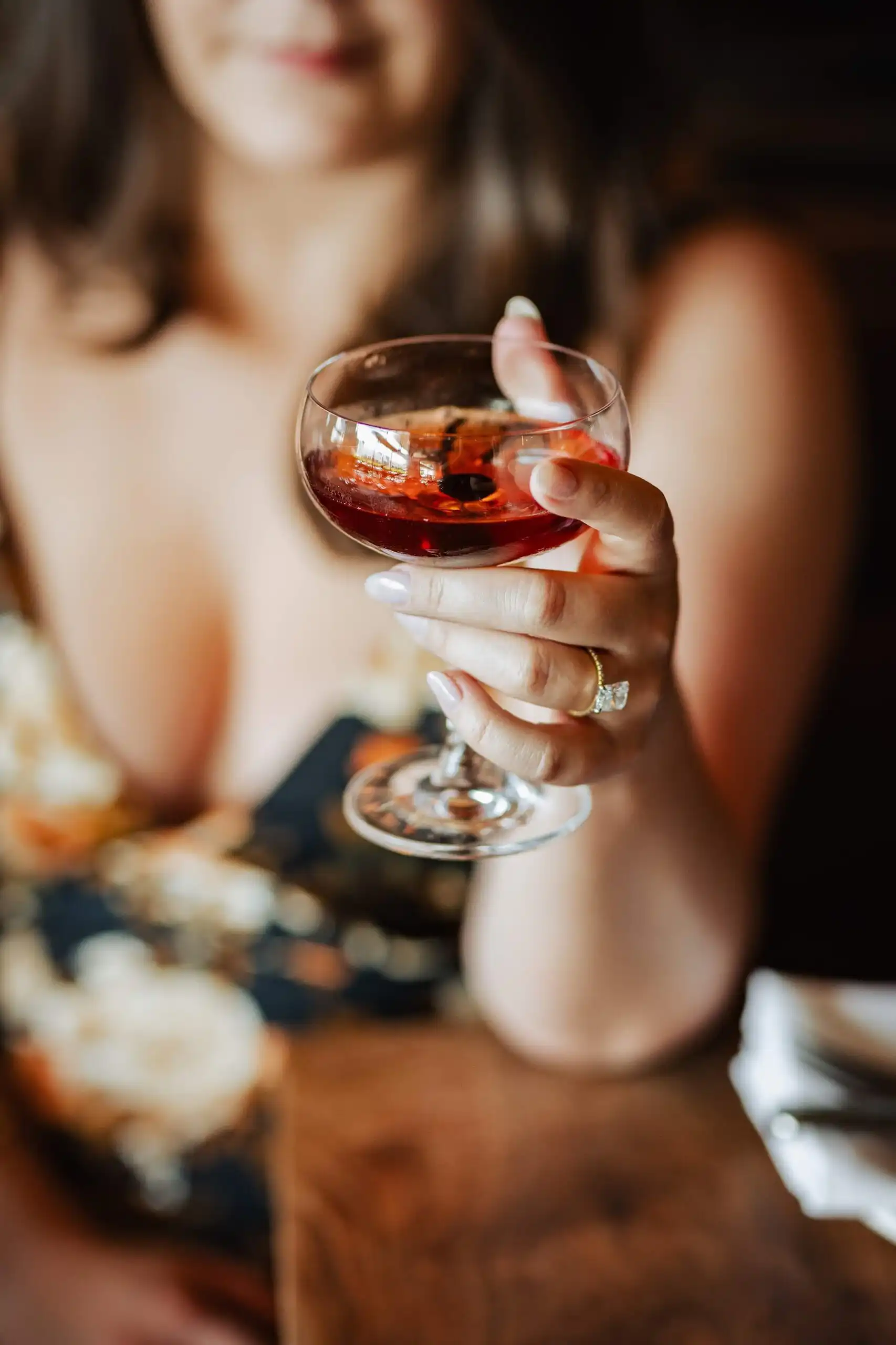 Engagement Portraits: her glass of wine held up, the ring in frame, during their engagement session