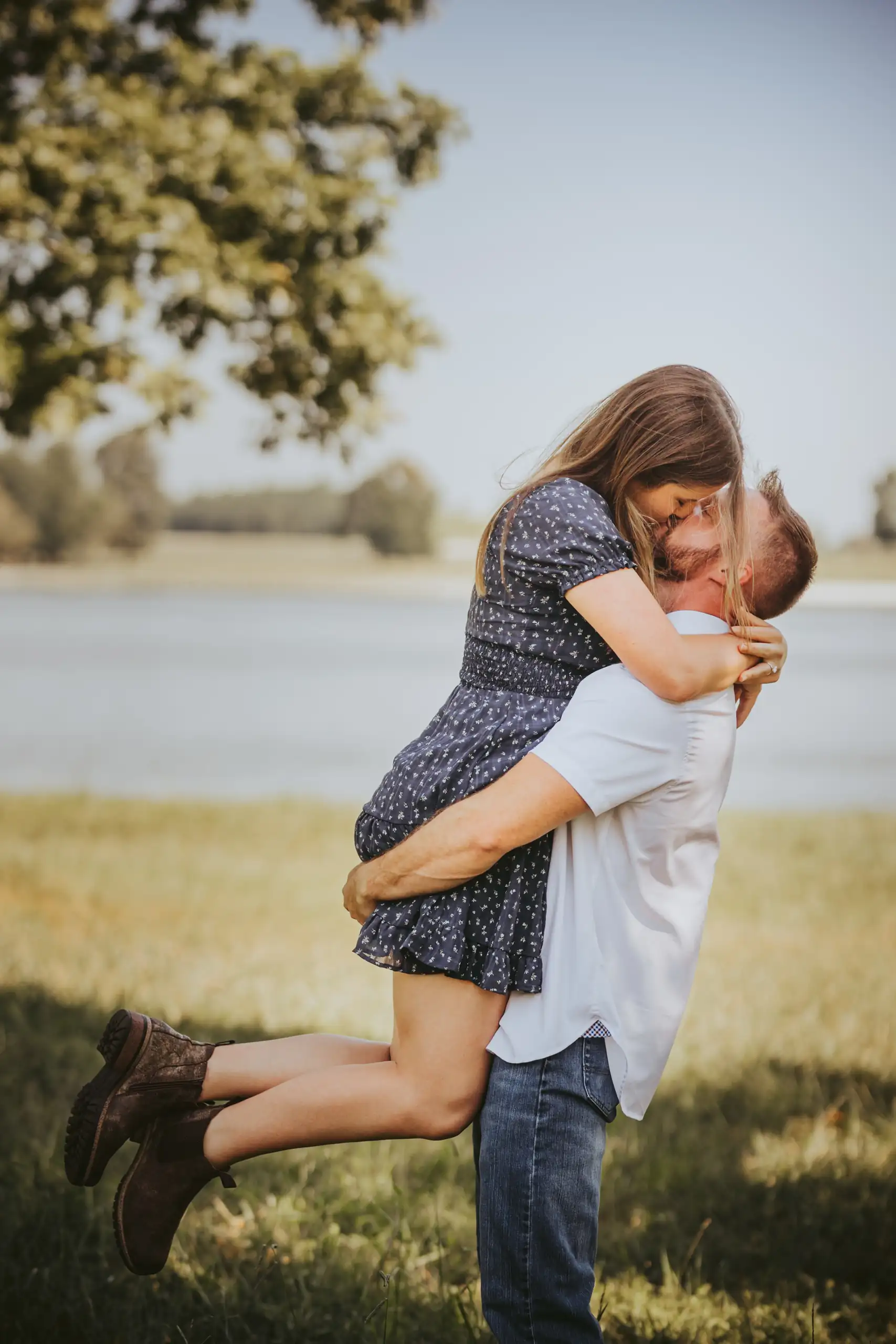 Engagement Portraits: him lifting her up in the open field, during their engagement session