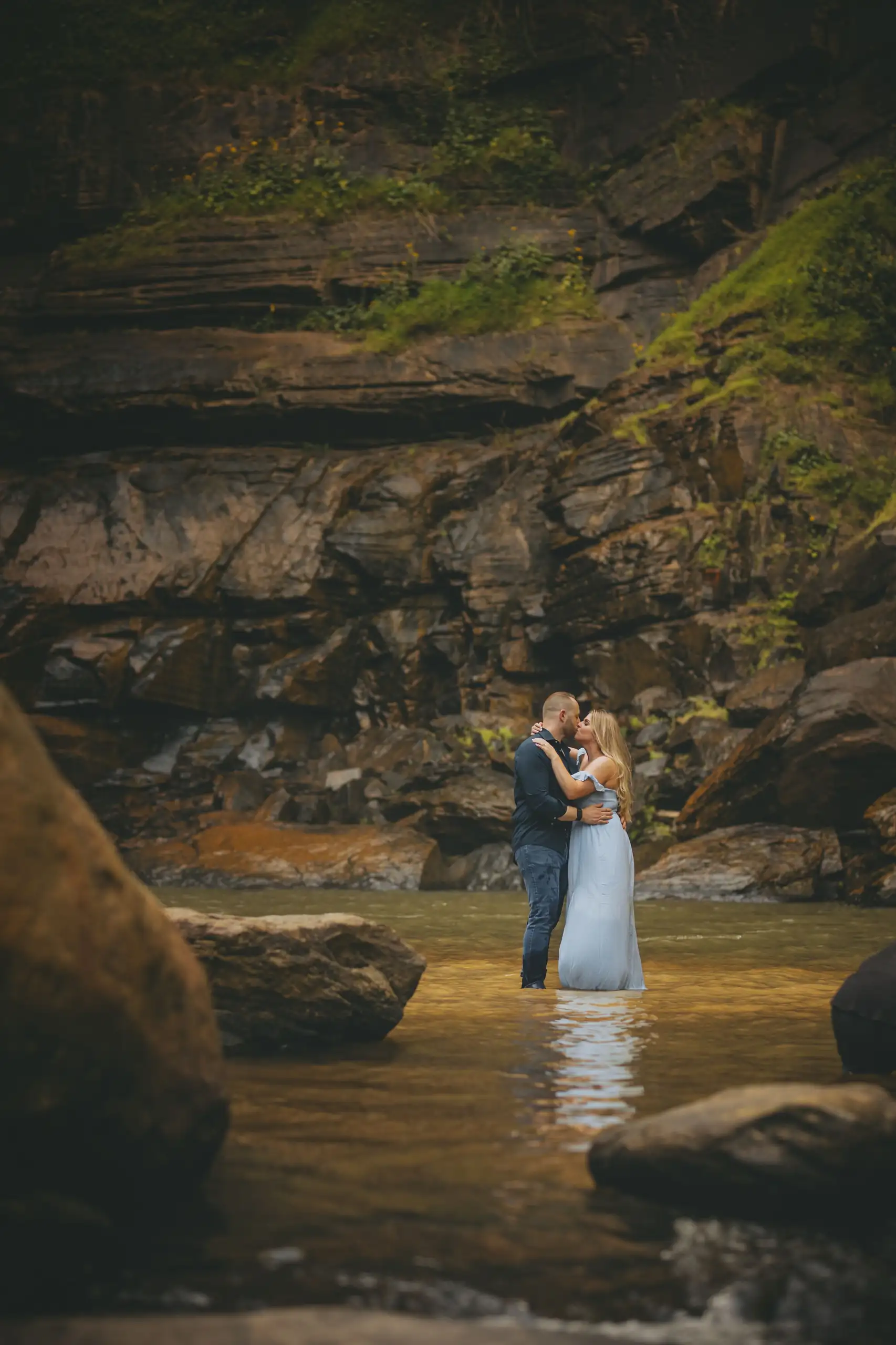 Engagement Portraits: the two of them standing in the shallows in the gorge, during their engagement session at Toccoa Falls in Toccoa, GA