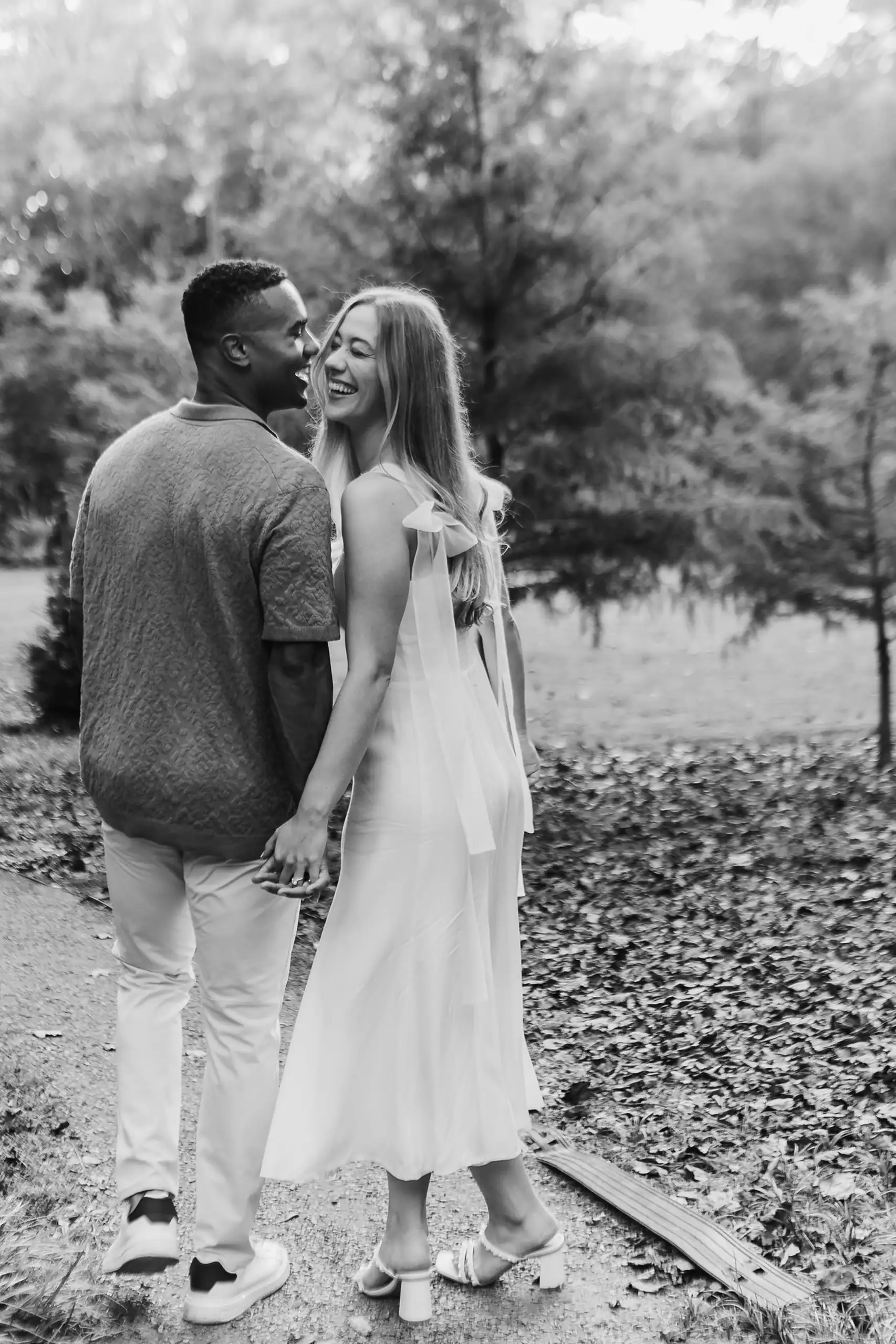 Engagement Portraits: the couple face to face in the woods, in black and white, during their engagement session