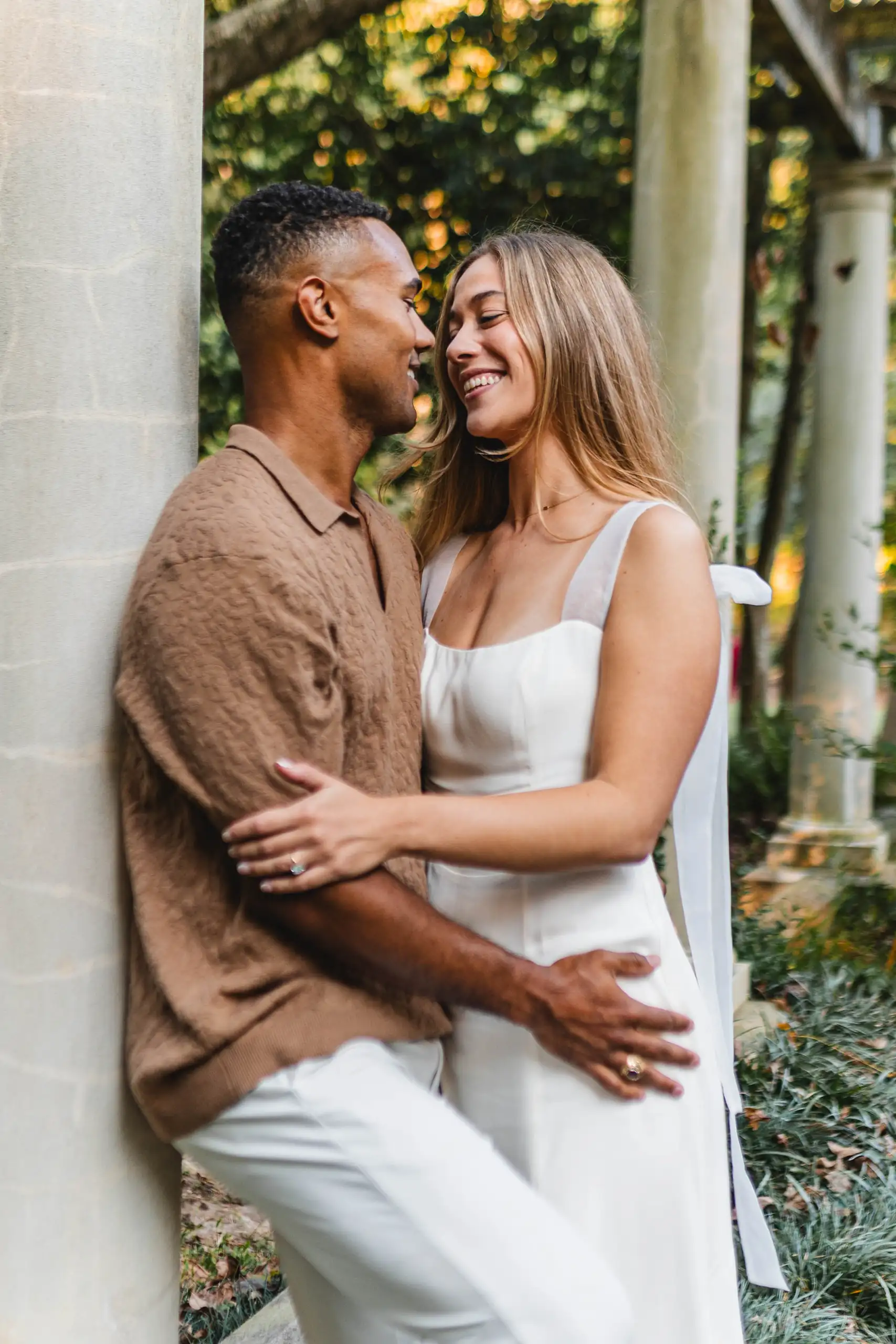 Engagement Portraits: the two of them leaning together against the column, during their engagement session