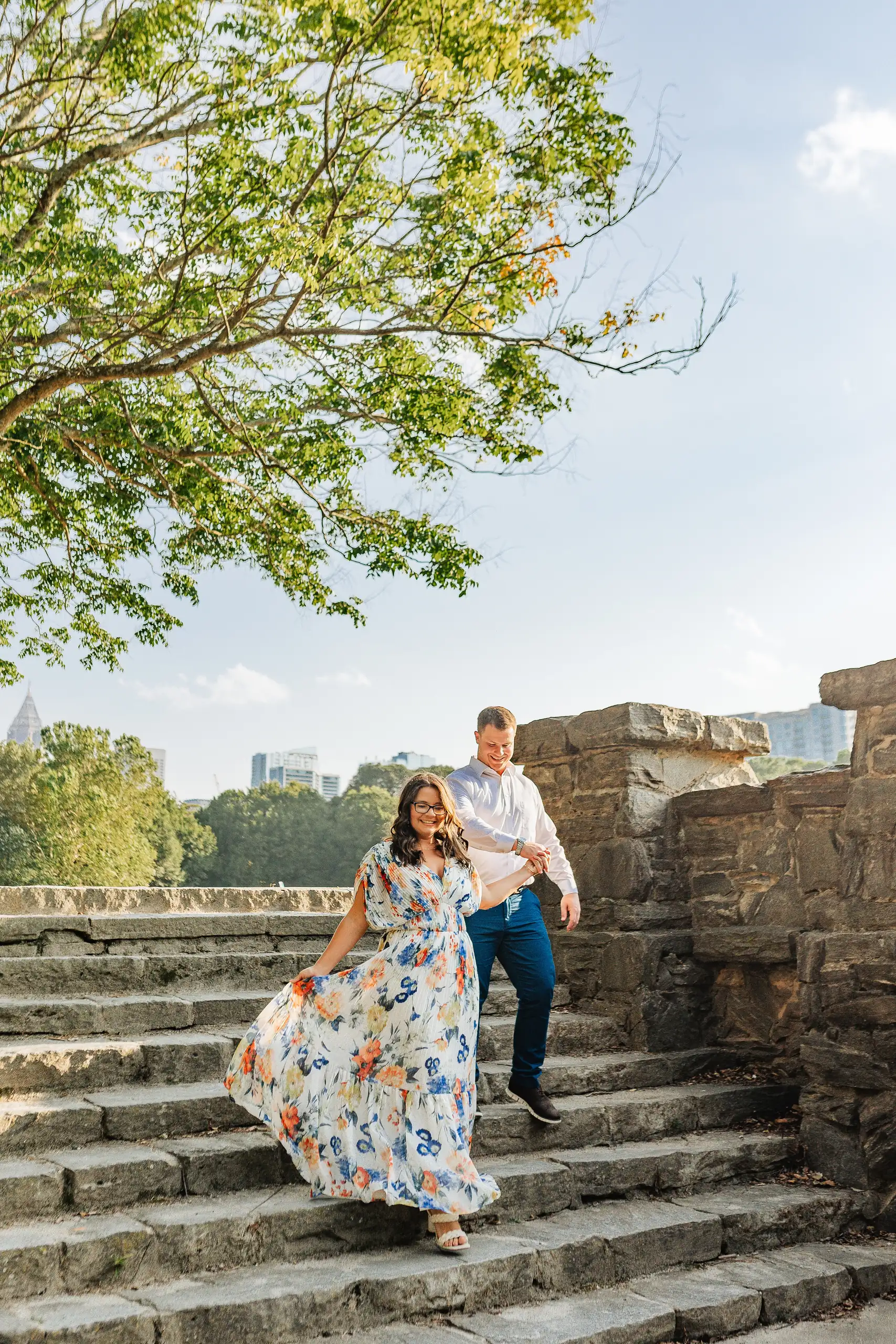 Engagement Portraits: the couple coming down the stone steps together, during their engagement session at Piedmont Park in Atlanta, GA