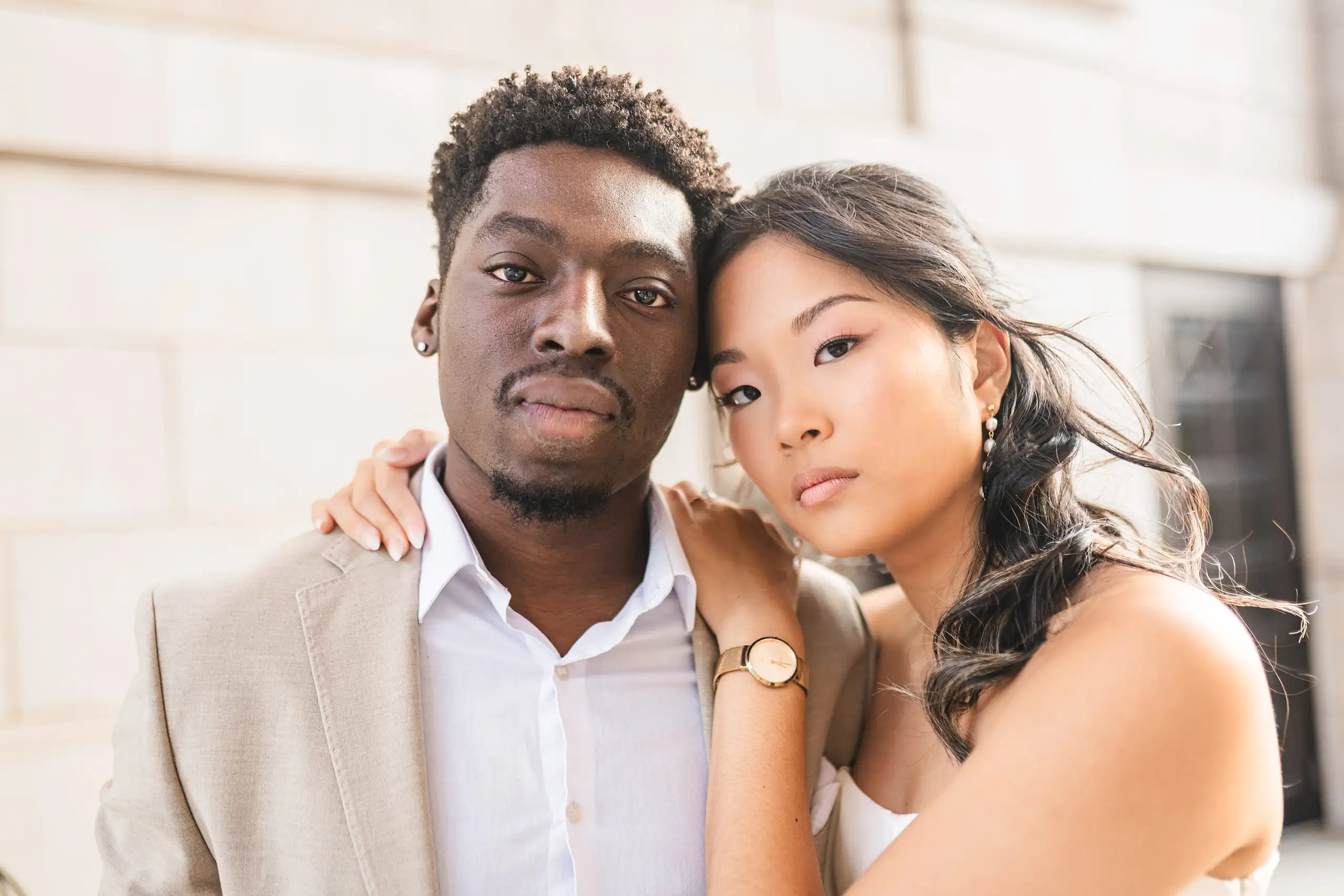Engagement Portraits: her head on his shoulder against the pale stone, during their engagement session at the Millennium Gate in Atlanta, GA