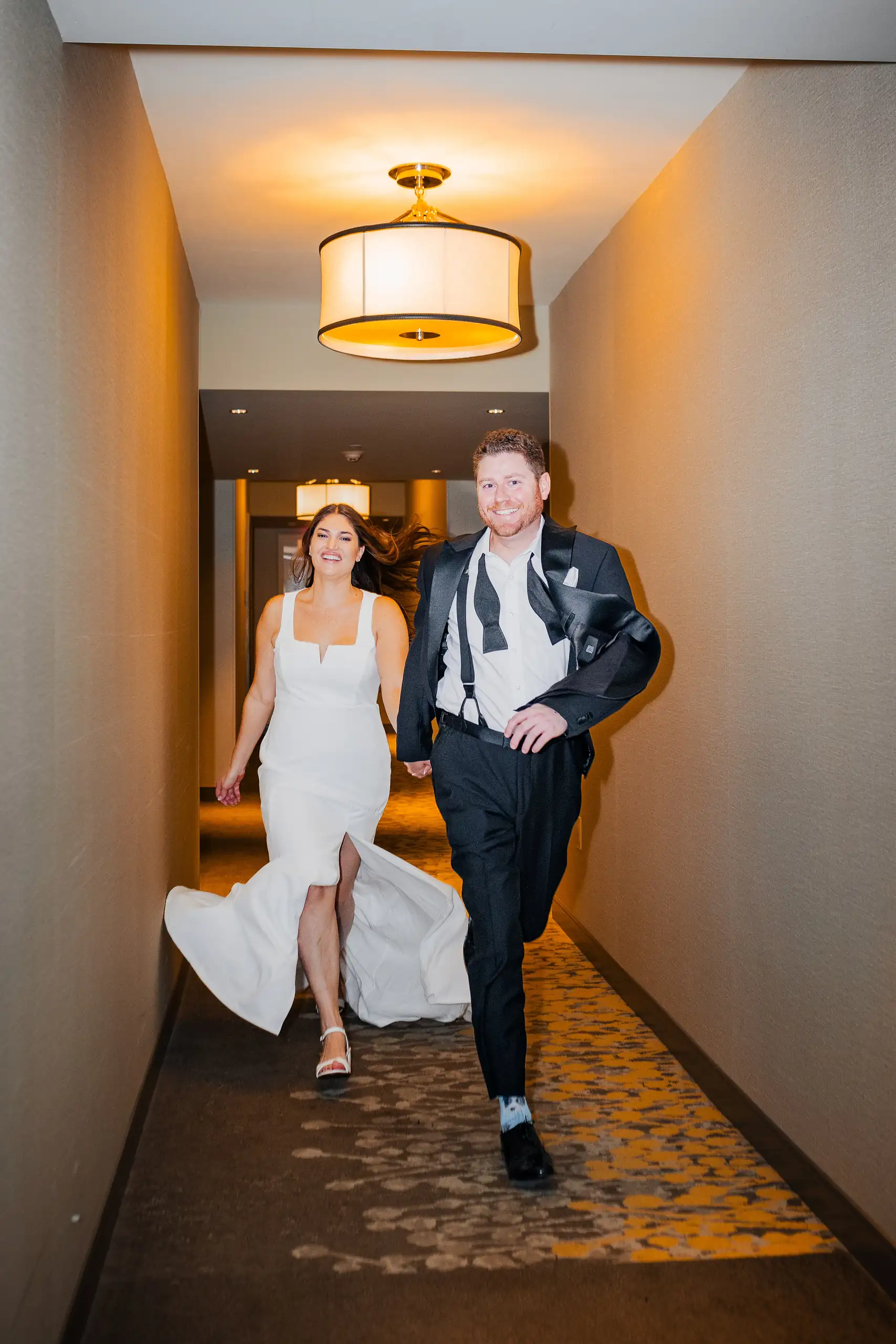 Engagement Portraits: walking the hotel corridor, her train behind her, during their engagement session at the Hotel at Avalon in Alpharetta, GA