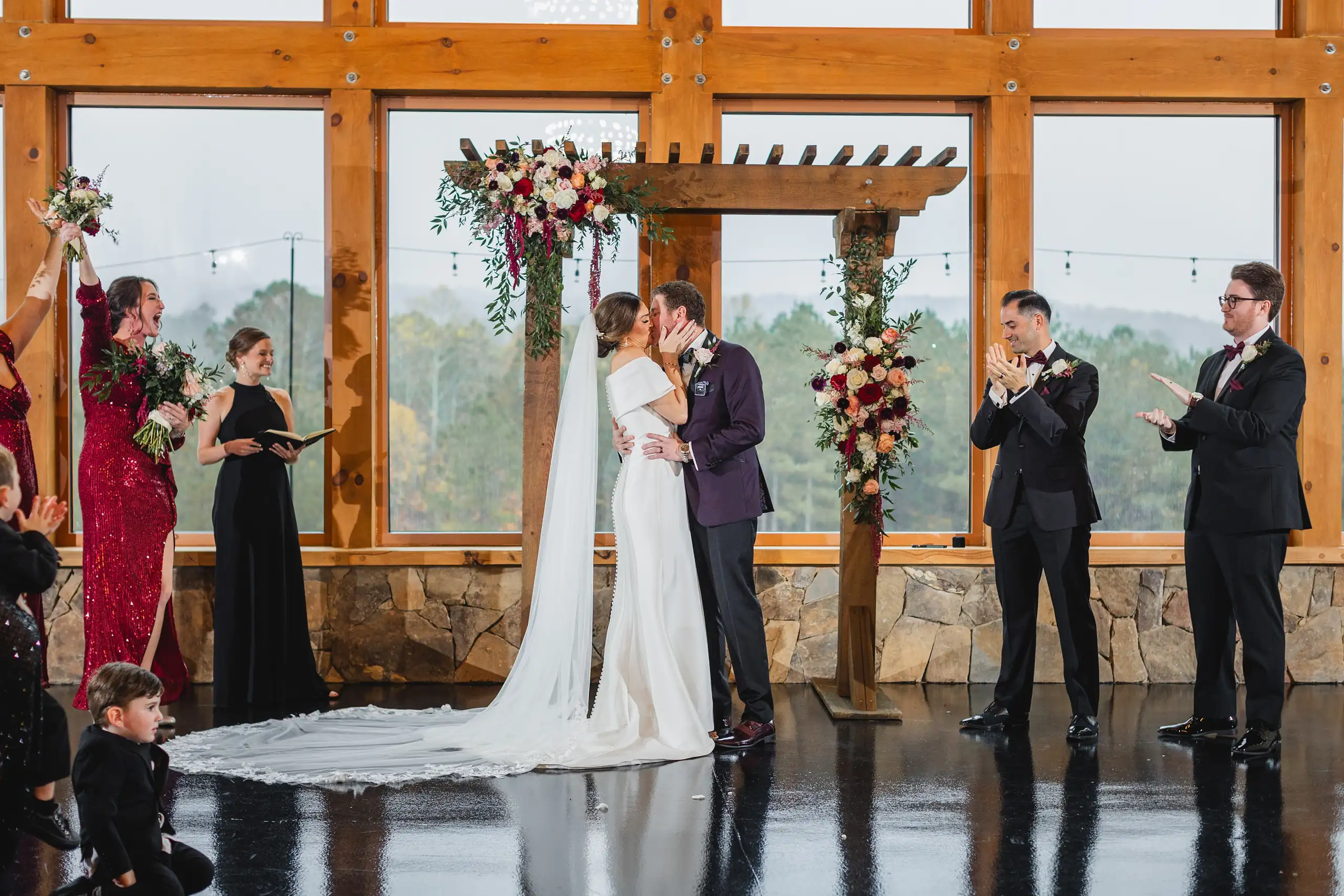 Wedding Ceremony: the vows at the flowered arbor, the mountains beyond, at their wedding at The Venue at Sharp Mountain in Jasper, GA