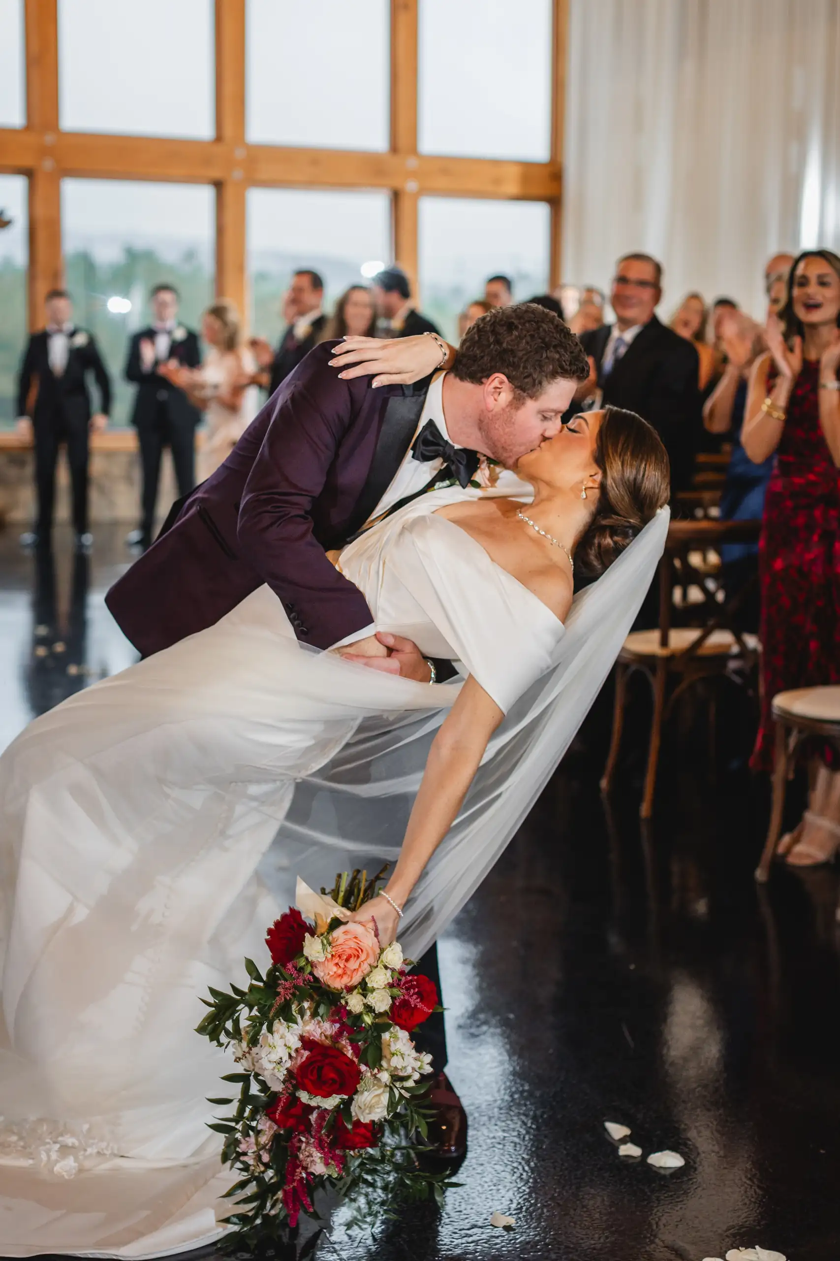 Wedding Ceremony: the first kiss, dipped low, as the guests applaud, at their wedding at The Venue at Sharp Mountain in Jasper, GA