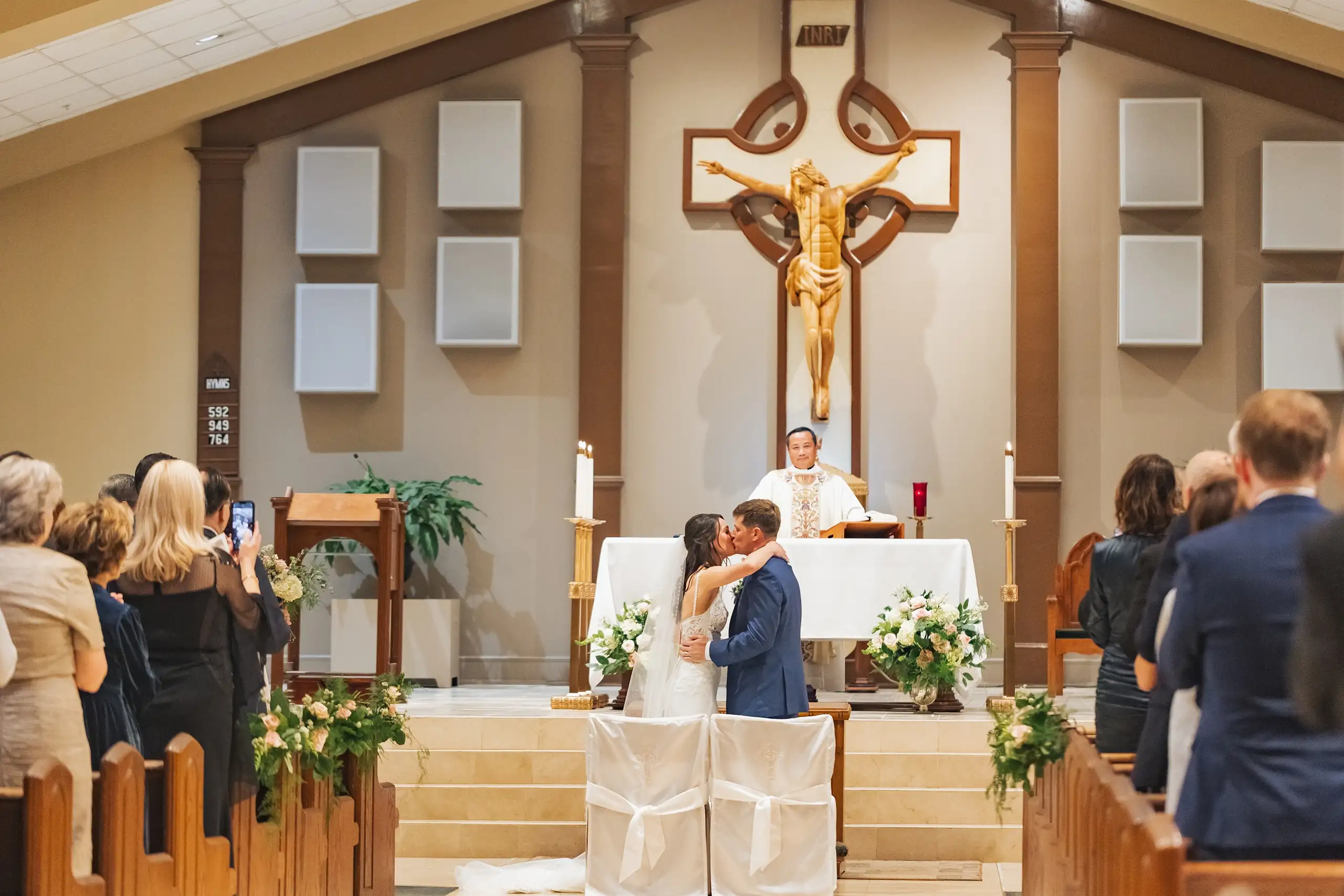 Wedding Ceremony: the vows said at the church altar beneath the crucifix, at their wedding at Swan Lake Overlook in Dawsonville, GA