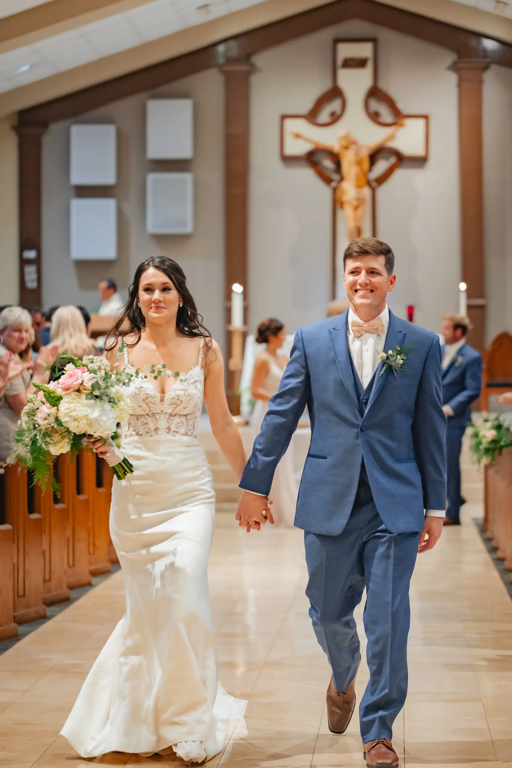 Recessional: the couple coming back down the church aisle, at their wedding at Swan Lake Overlook in Dawsonville, GA