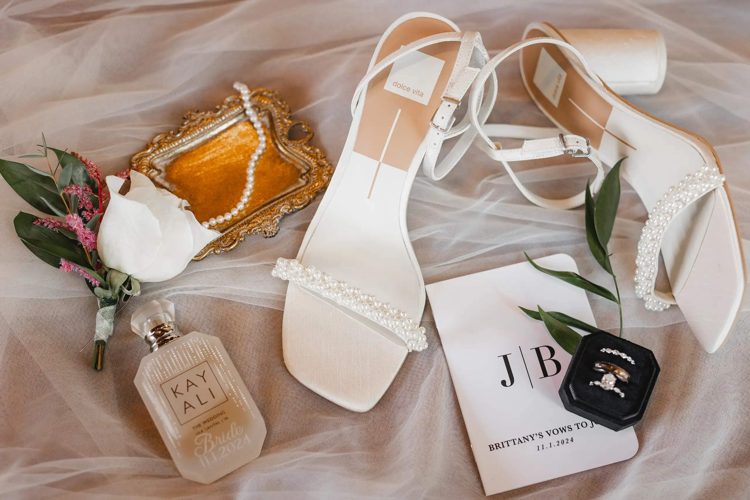 Wedding Details: her heels, perfume and vow book on the veil, at a wedding at The Venue at Sharp Mountain in Jasper, GA