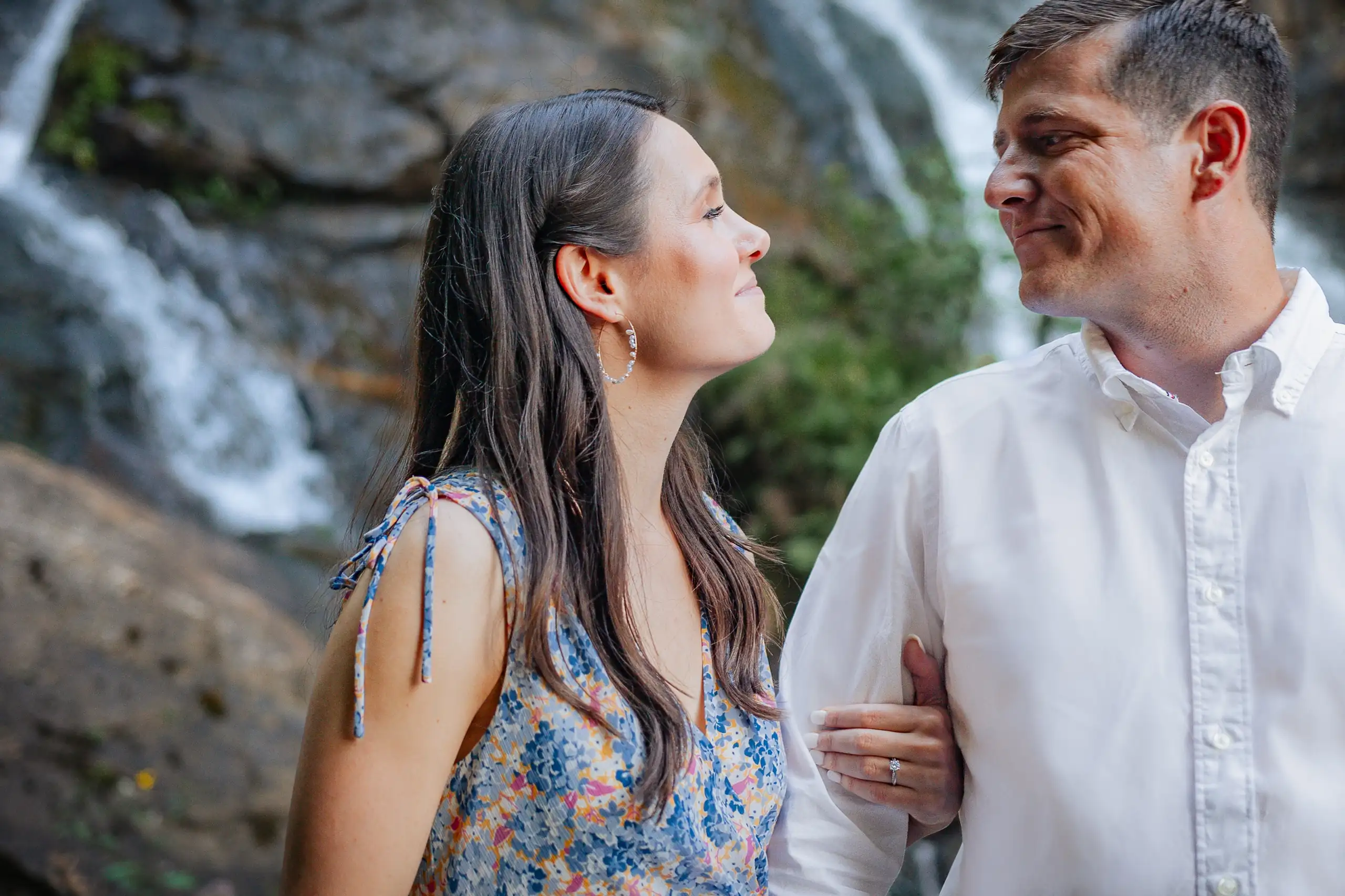 Engagement Portraits: the couple with the water falling behind them, at their engagement session at Amicalola Falls in Dawsonville, GA