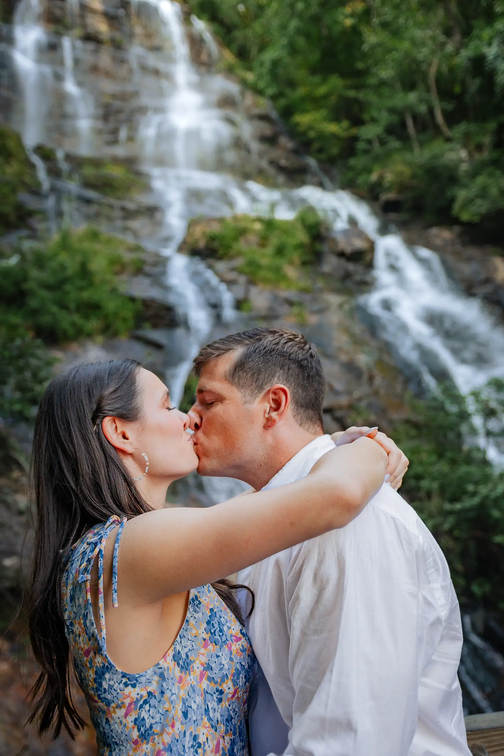 Engagement Portraits: a kiss in front of the falls, at their engagement session at Amicalola Falls in Dawsonville, GA