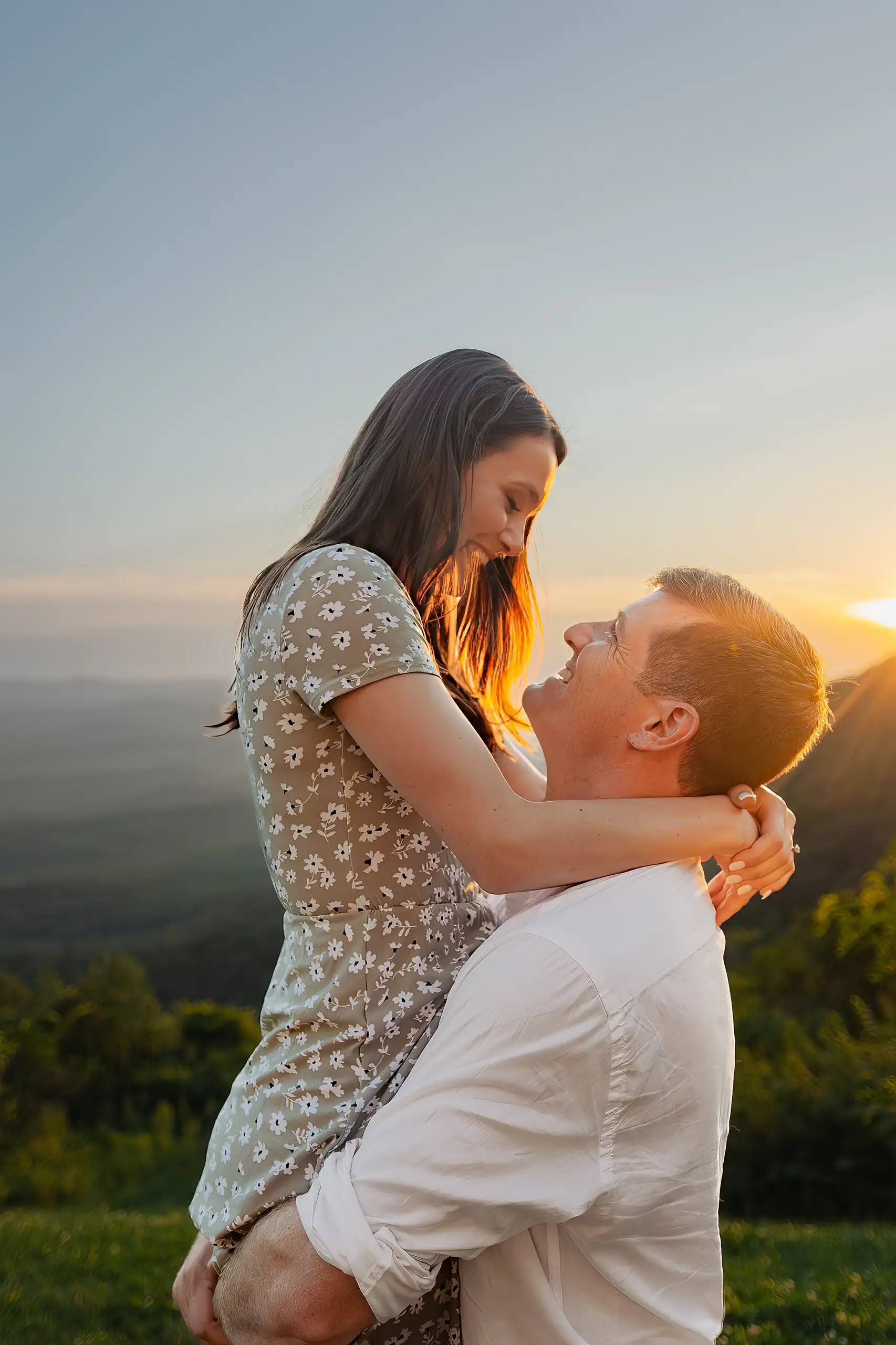 Engagement Portraits: the groom-to-be lifting her into the sunset light, at their engagement session at Amicalola Falls in Dawsonville, GA
