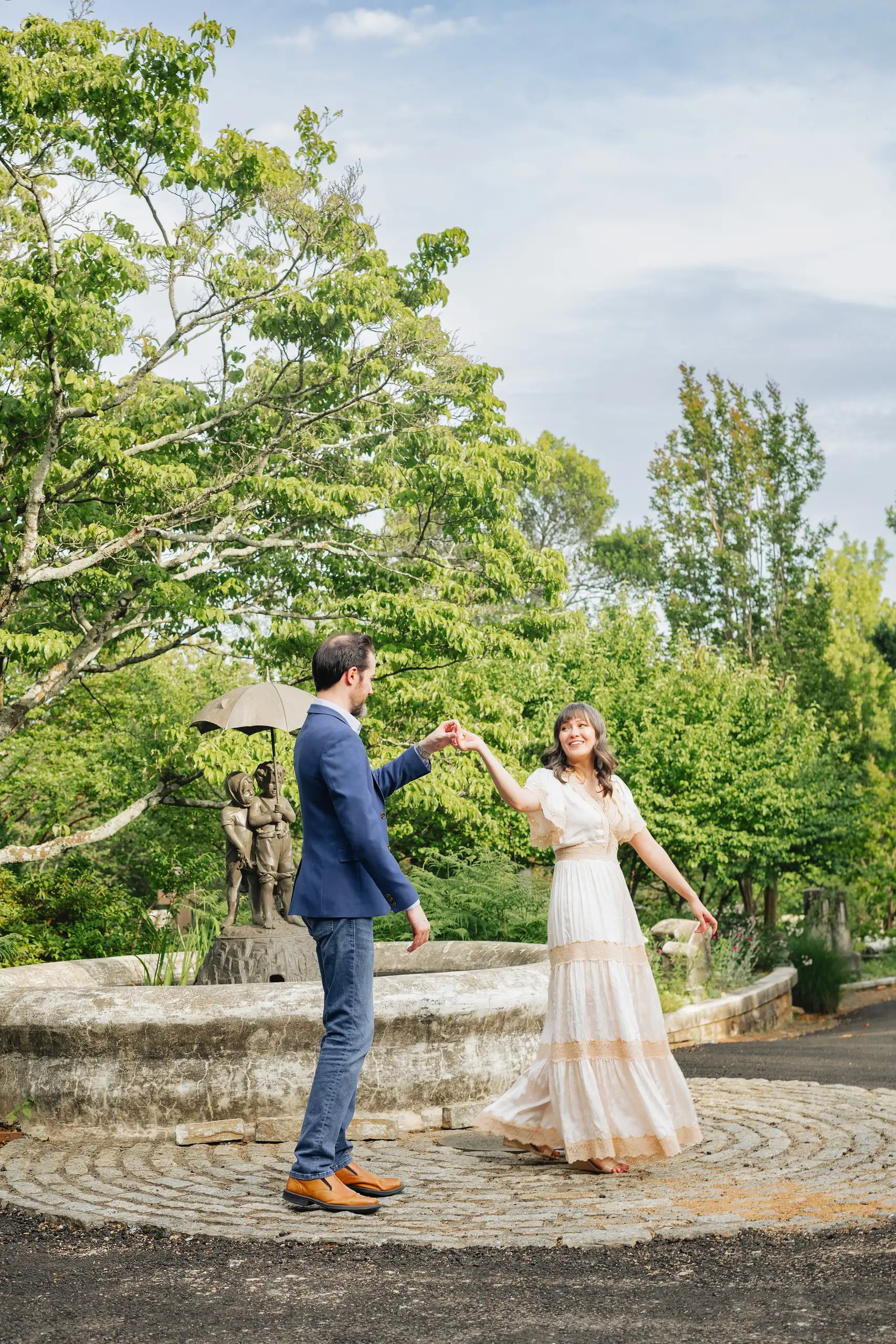 Engagement Portraits: him turning her out on the stone terrace, during their engagement session at Oakland Cemetery in Atlanta, GA