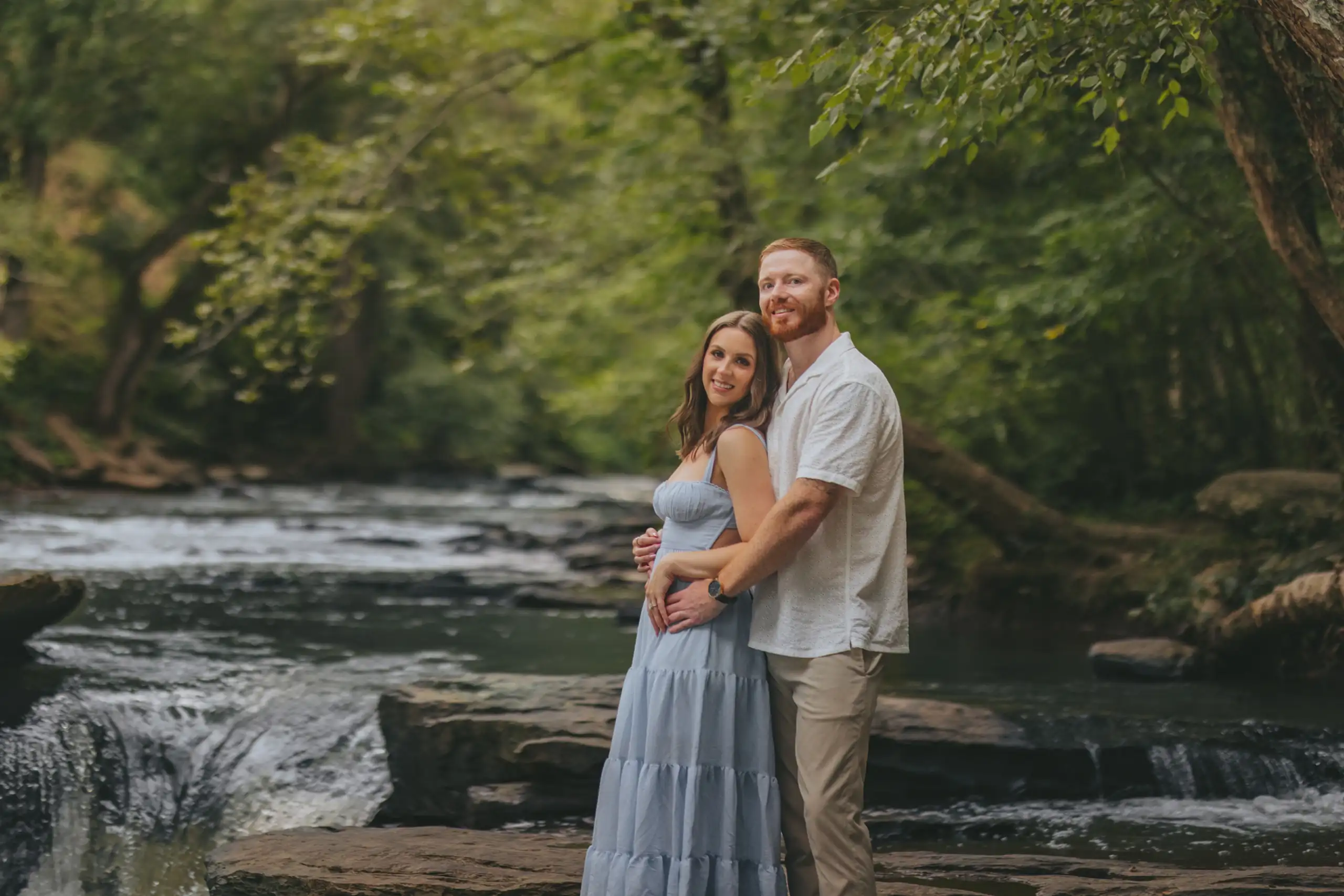 Engagement Portraits: the couple on the rocks above the falls, during their engagement session at Vickery Creek in Roswell, GA
