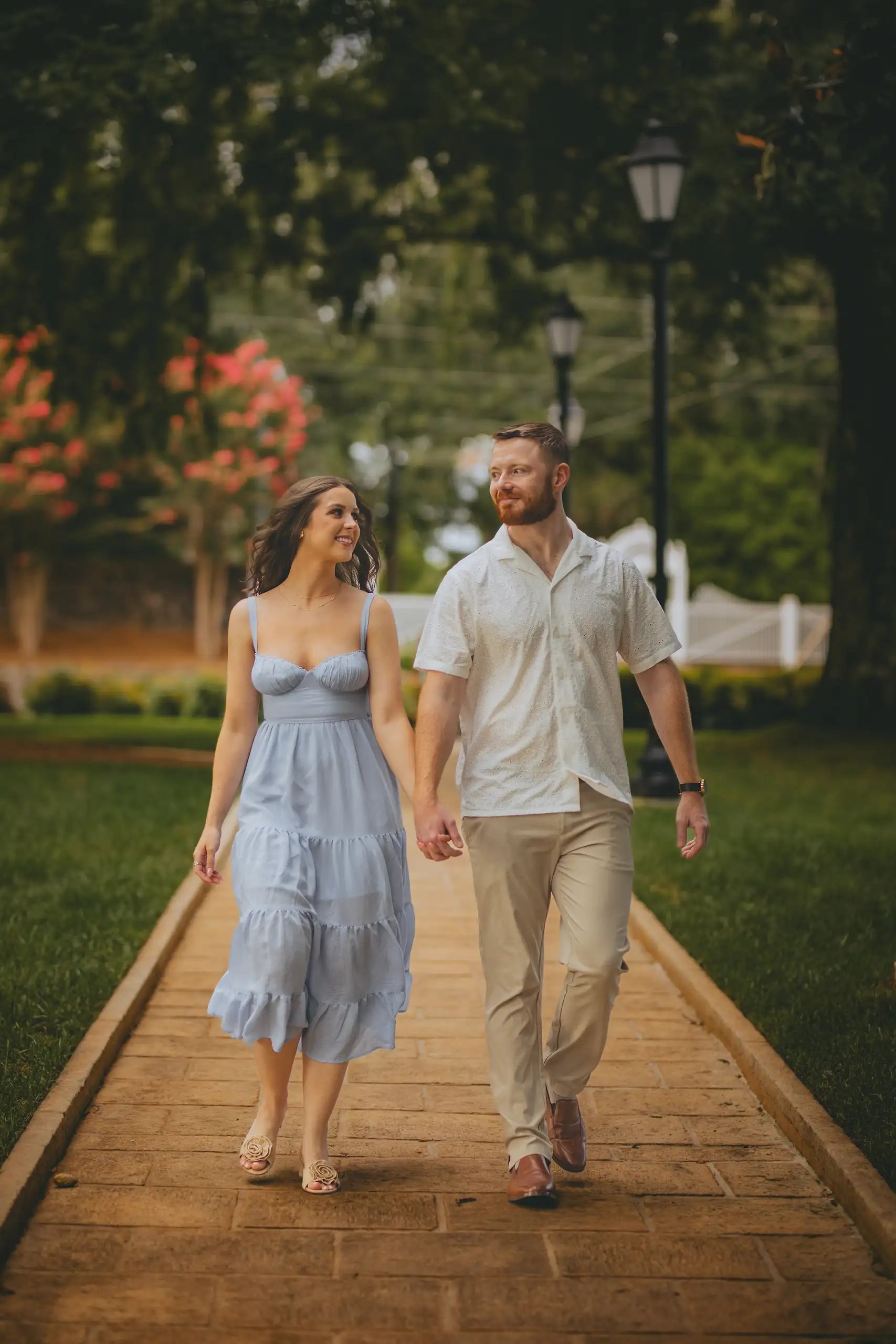 Engagement Portraits: the two of them walking the boardwalk, her skirt trailing, during their engagement session at Vickery Creek in Roswell, GA