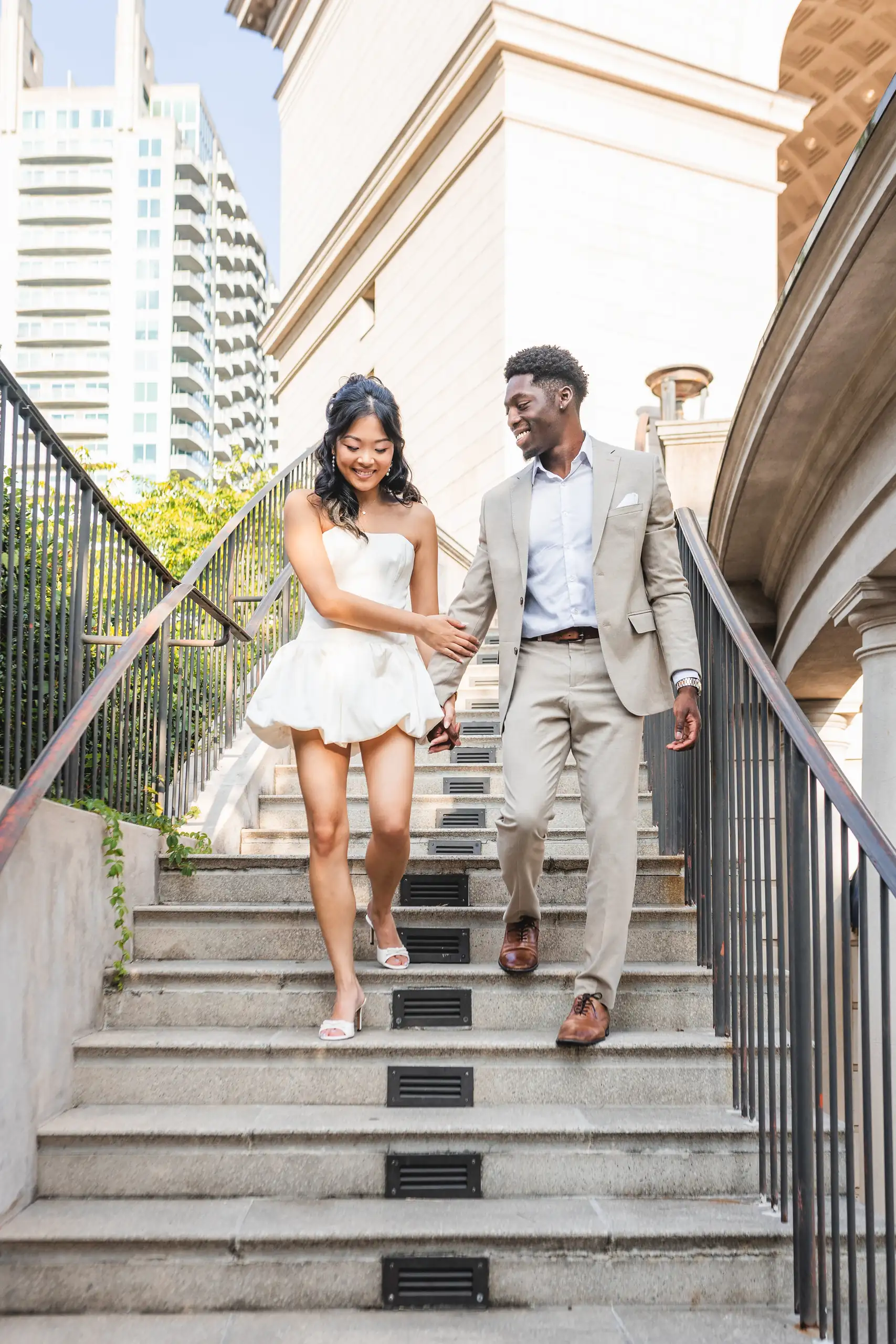 Engagement Portraits: the two of them coming down the marble steps, during their engagement session at the Millennium Gate in Atlanta, GA
