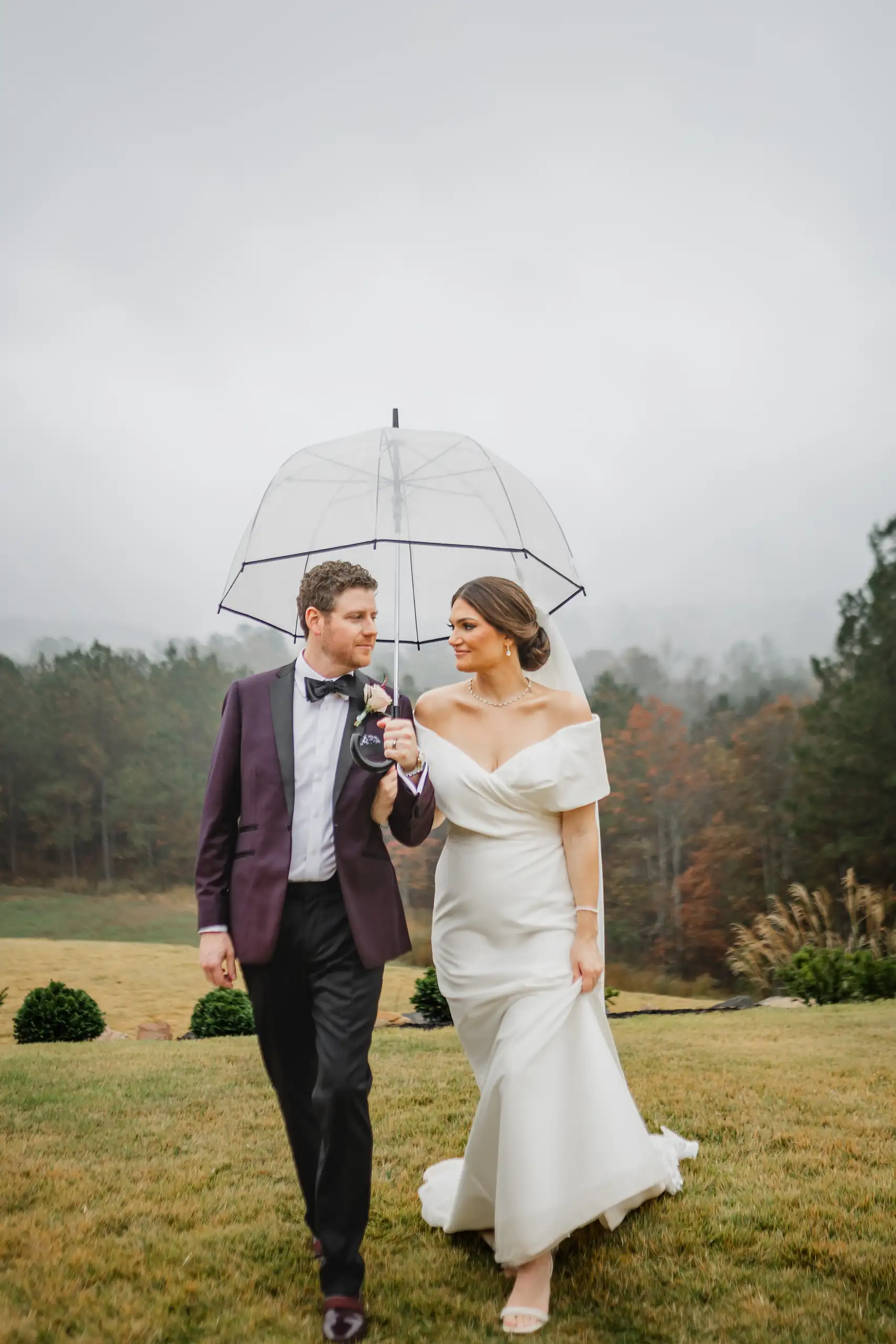 Wedding Formals: the two of them under a clear umbrella in the mist, at their wedding at The Venue at Sharp Mountain in Jasper, GA