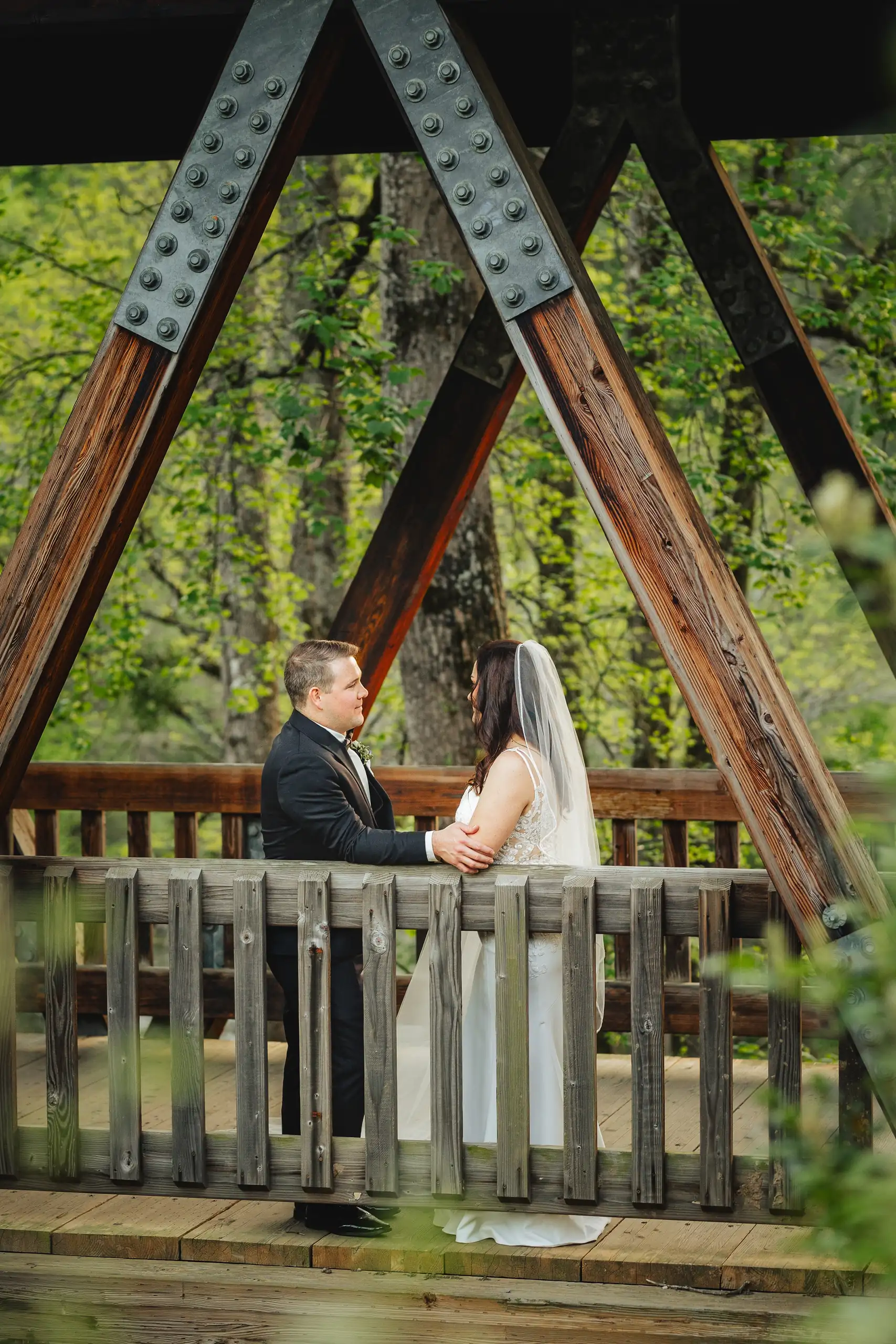 Wedding Formals: the couple under the timber trestle by the water, at their wedding at Ivy Hall at the Roswell Mill in Roswell, GA