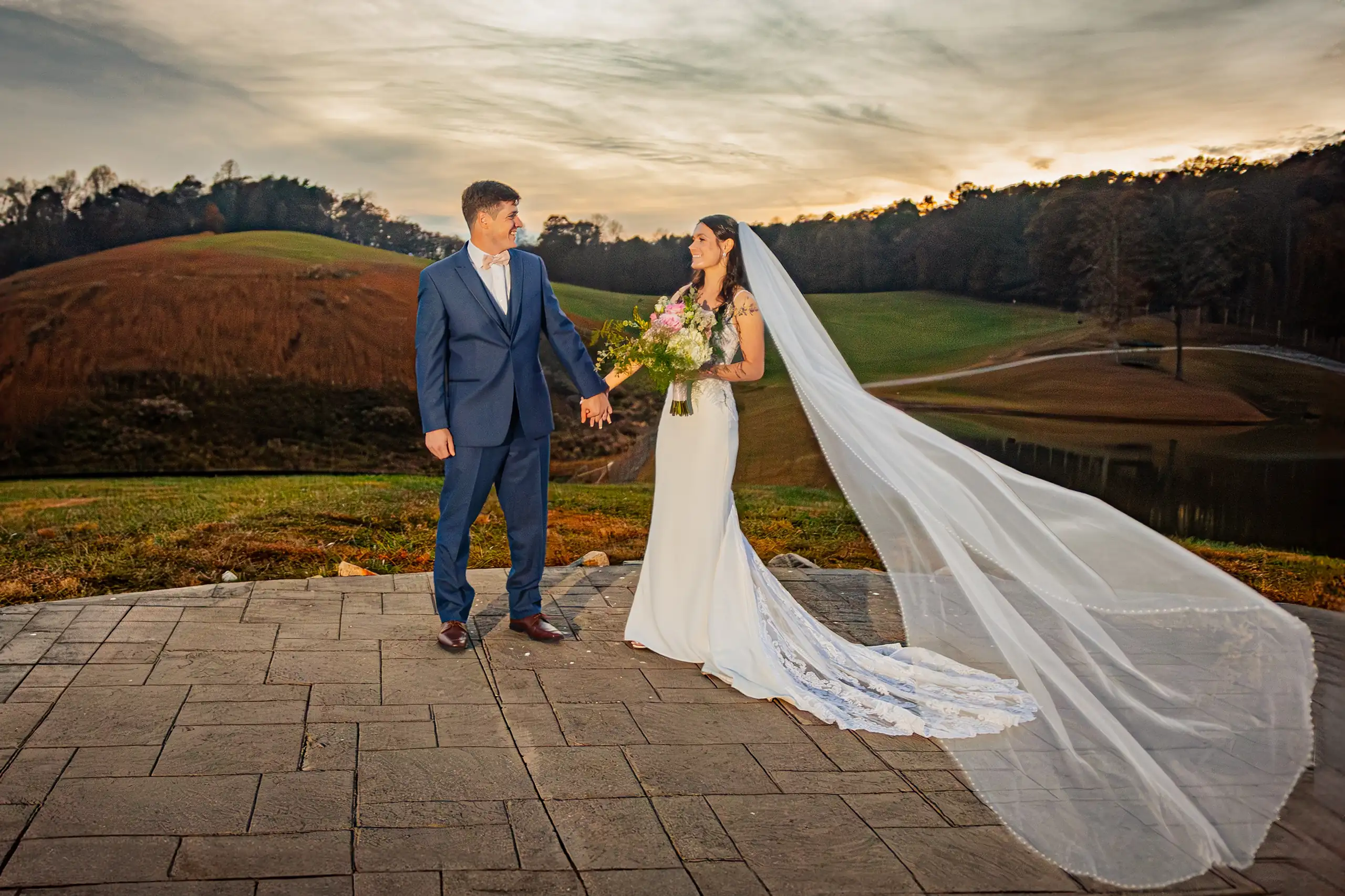 Wedding Formals: her cathedral veil out across the terrace at sunset, at their wedding at Swan Lake Overlook in Dawsonville, GA