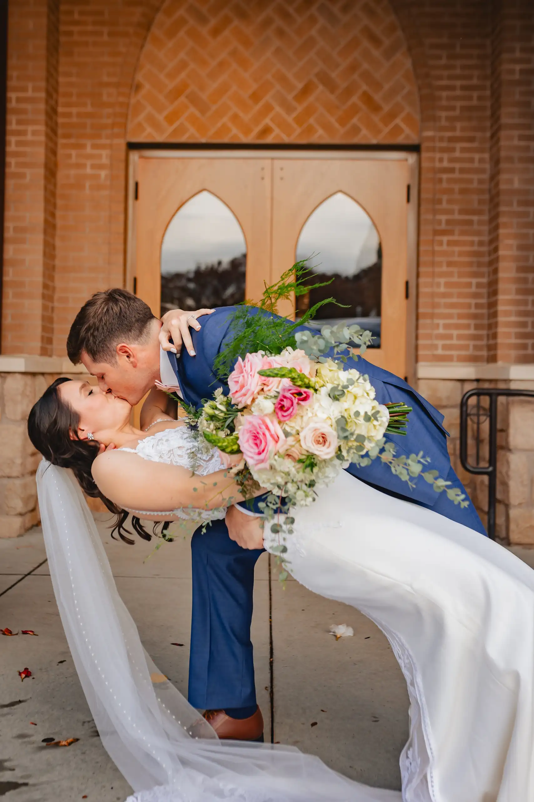Wedding Formals: the groom dipping her outside the church doors, at their wedding at Swan Lake Overlook in Dawsonville, GA