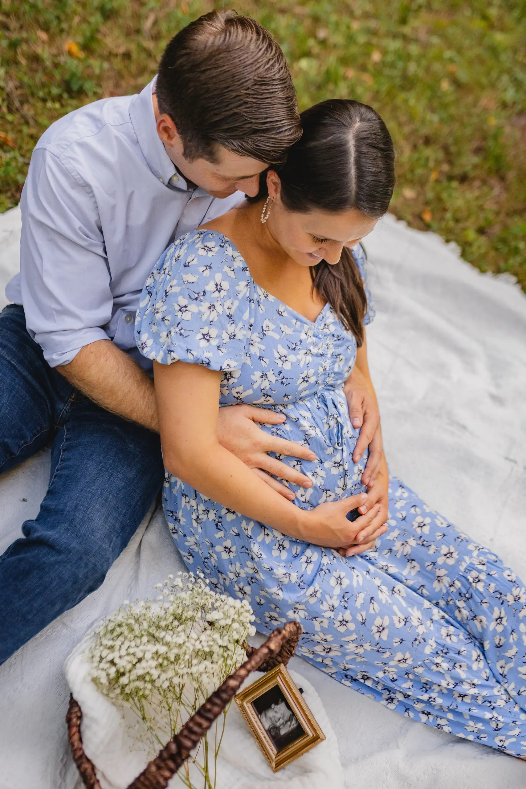 Maternity Portraits: the couple on the blanket with the scan beside them, at their maternity session in Ball Ground, GA