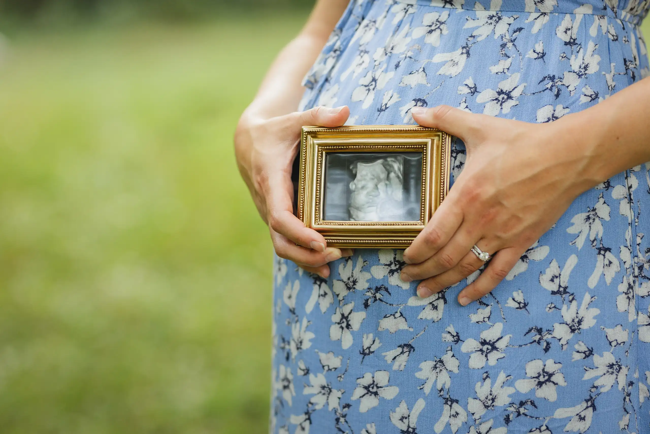 Maternity Portraits: the sonogram in a gold frame held at her bump, at their maternity session in Ball Ground, GA