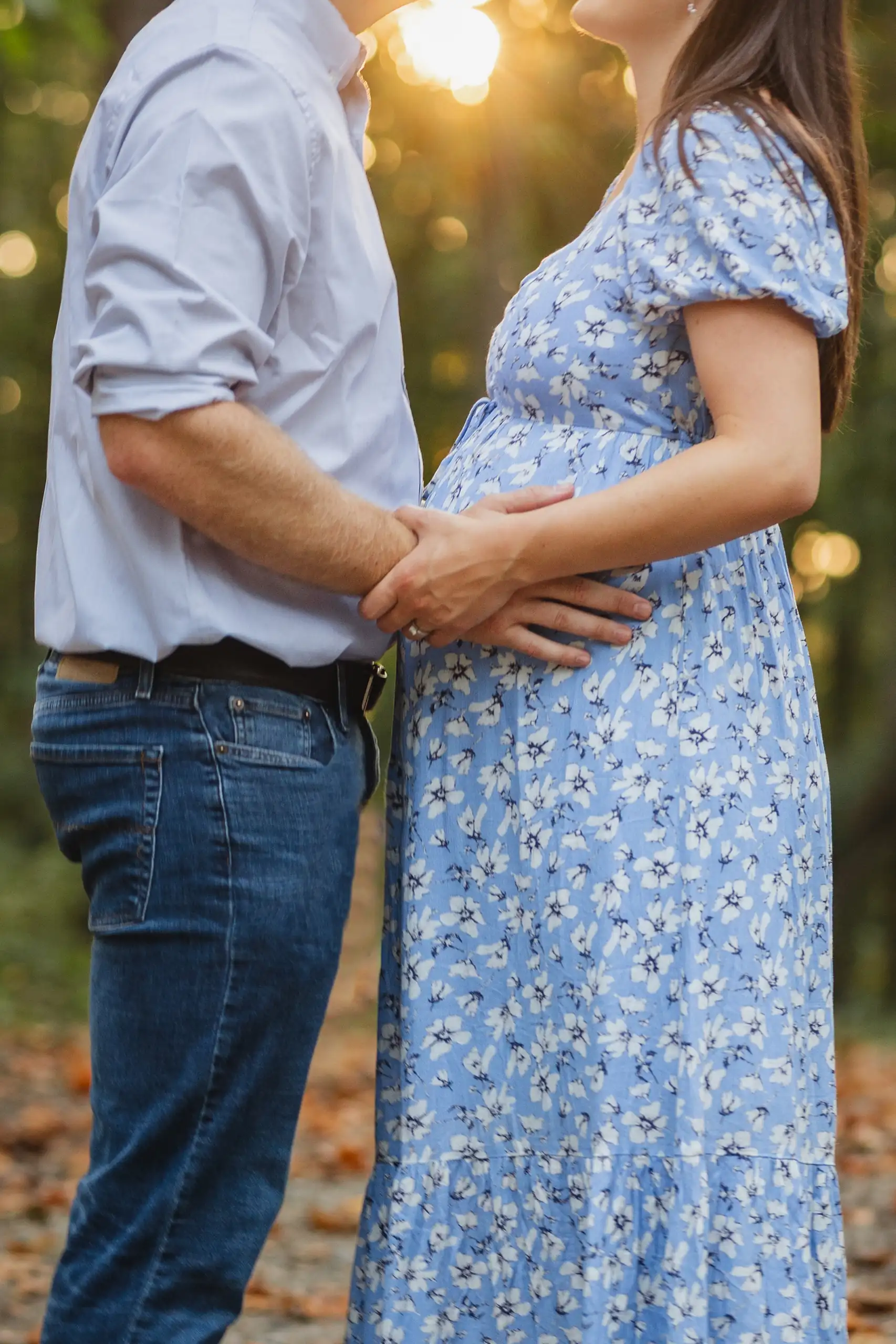 Maternity Portraits: both their hands resting on her bump in the low sun, at their maternity session in Ball Ground, GA