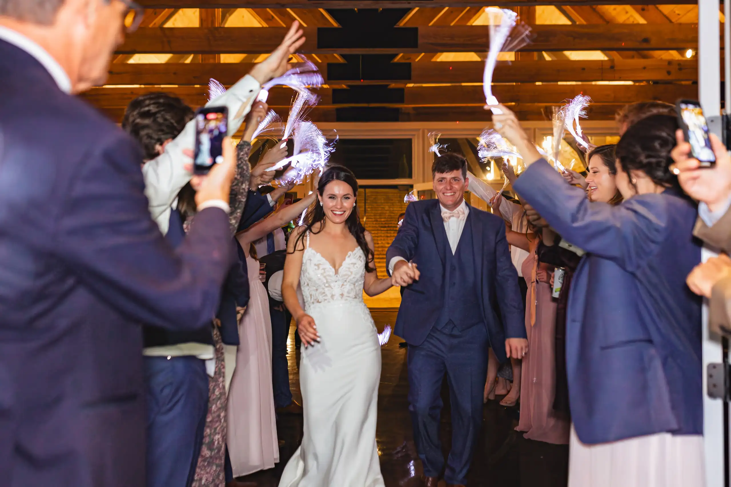 Send-Off: the couple walking out through raised wands, at their wedding at Swan Lake Overlook in Dawsonville, GA